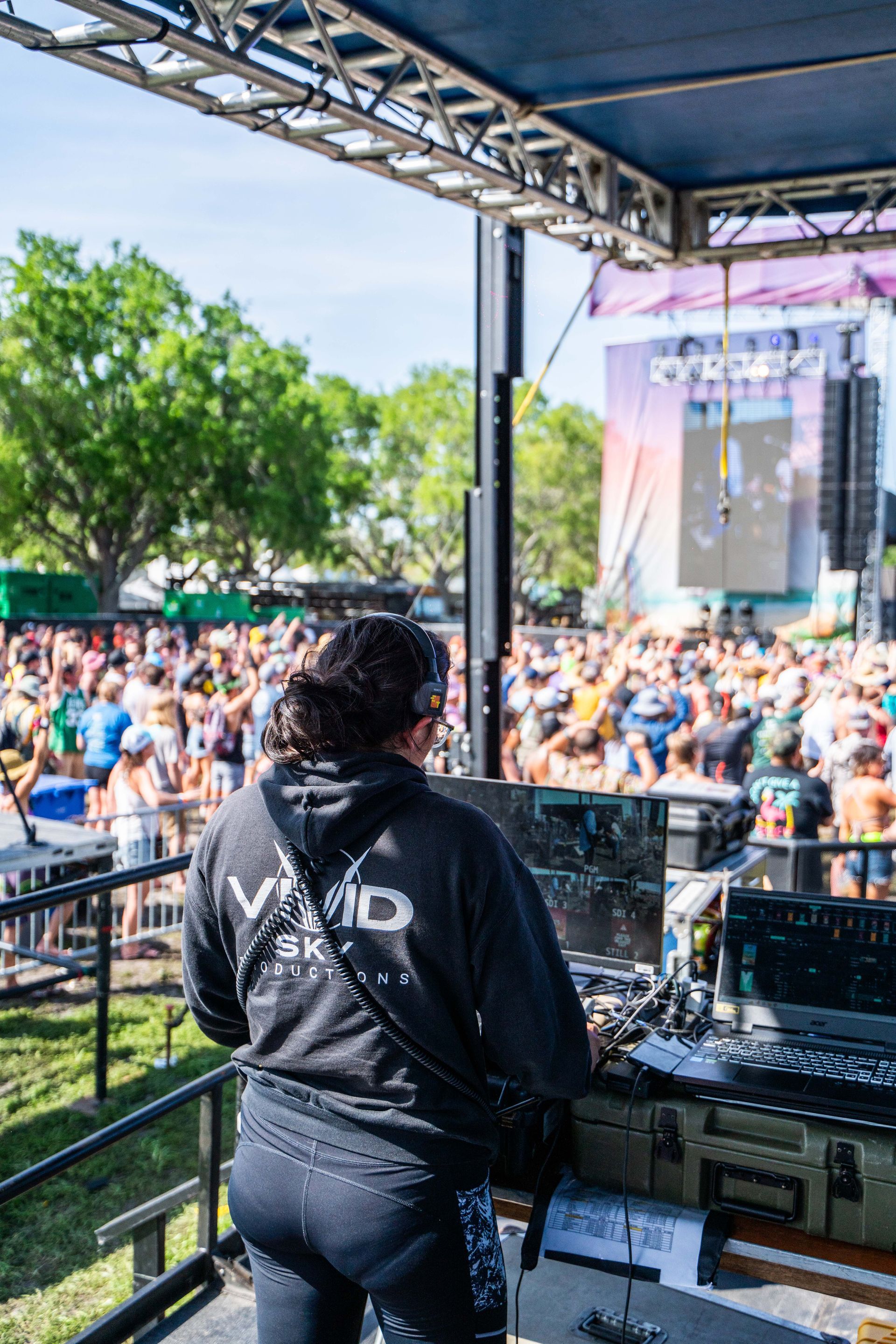 A woman is standing in front of a crowd at a music festival.