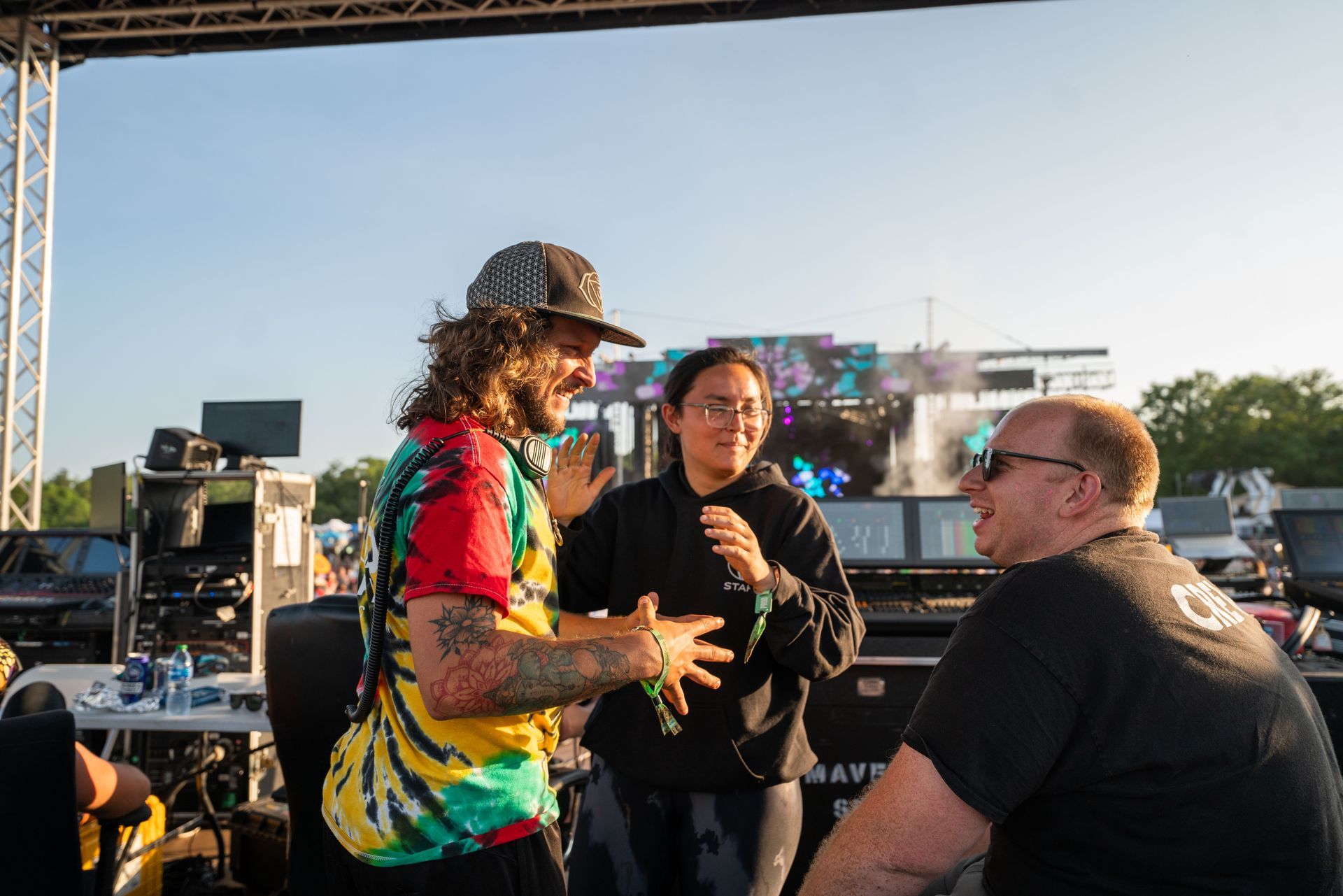 A group of people are standing in front of a stage talking to each other.