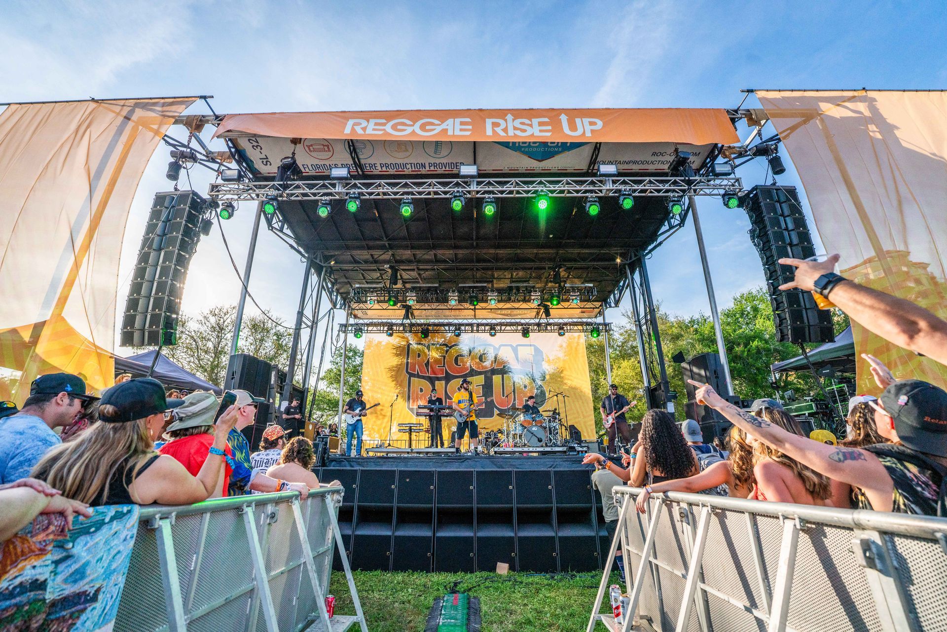 A group of people are standing in front of a stage at a concert.