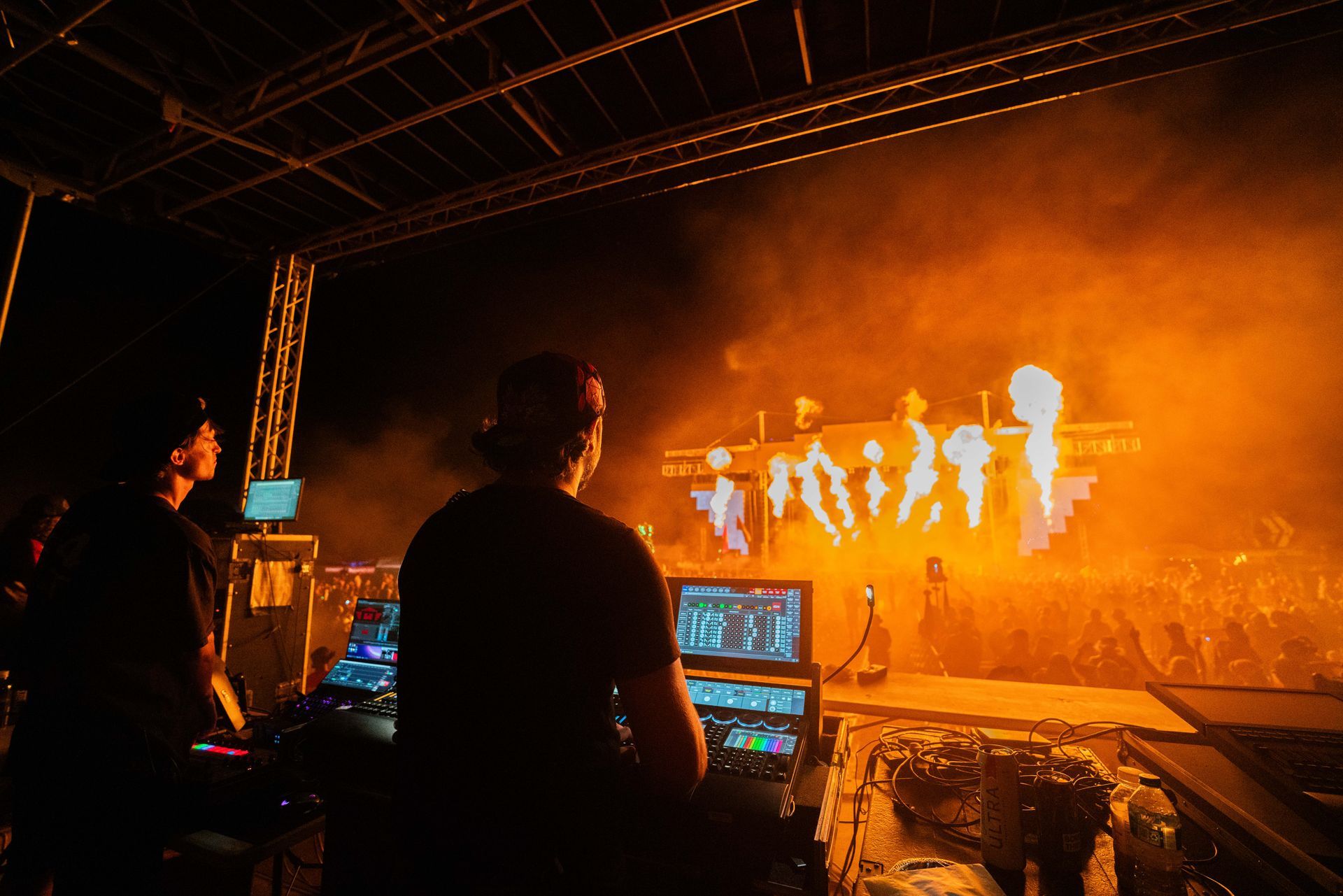 A man is standing in front of a stage at a concert.
