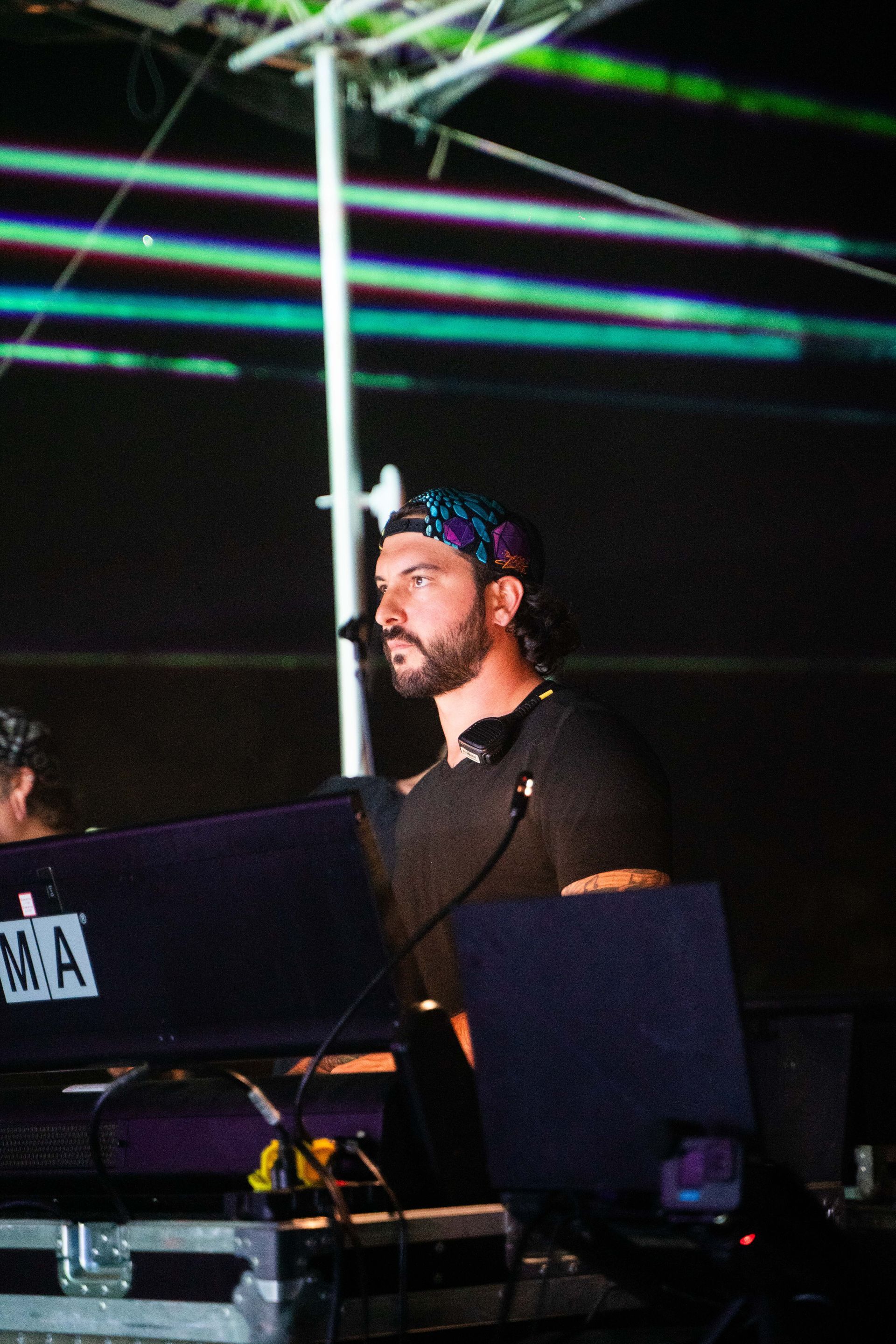 A man with a beard is playing a keyboard with the letter ma on it
