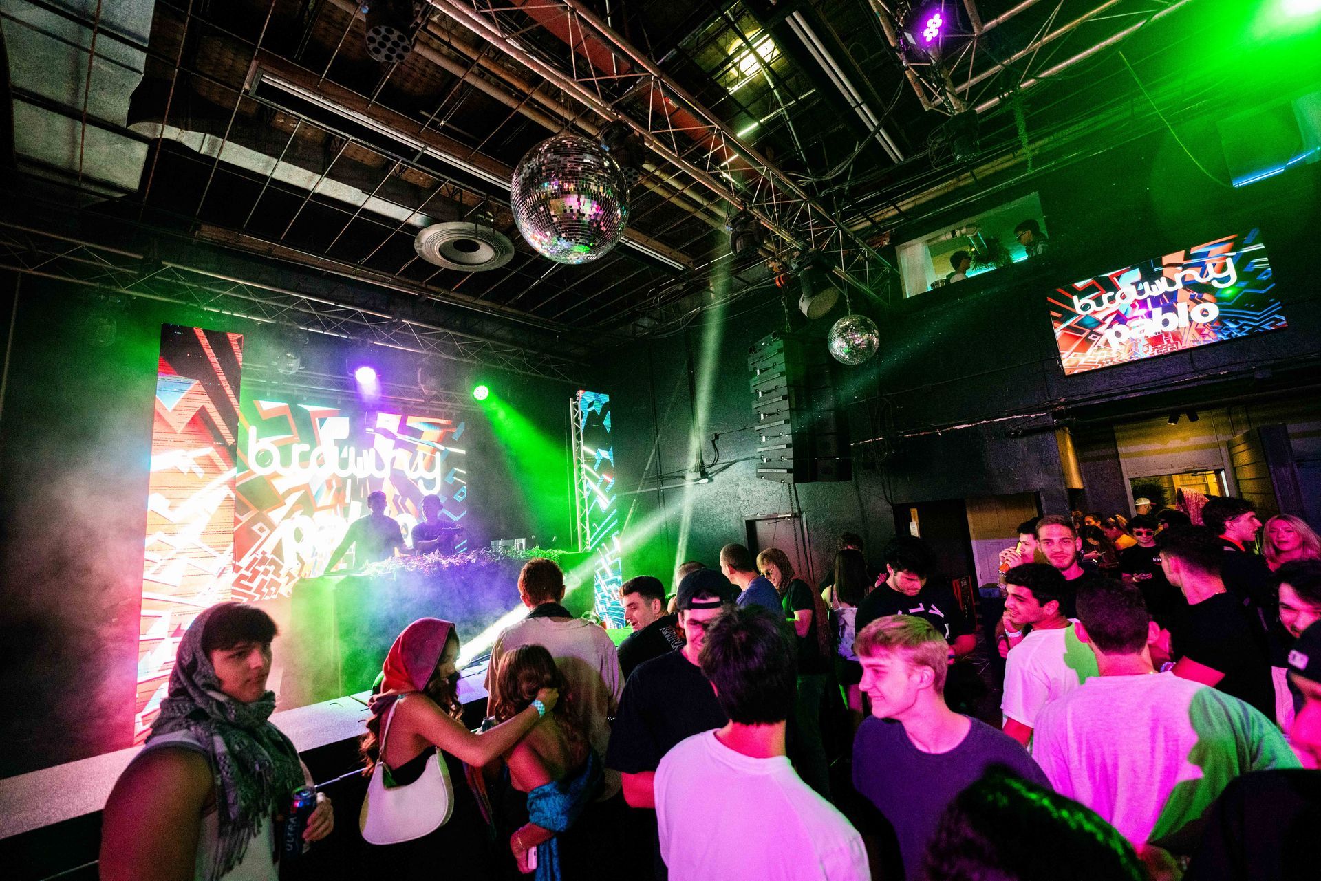 A large group of people are dancing in a club.