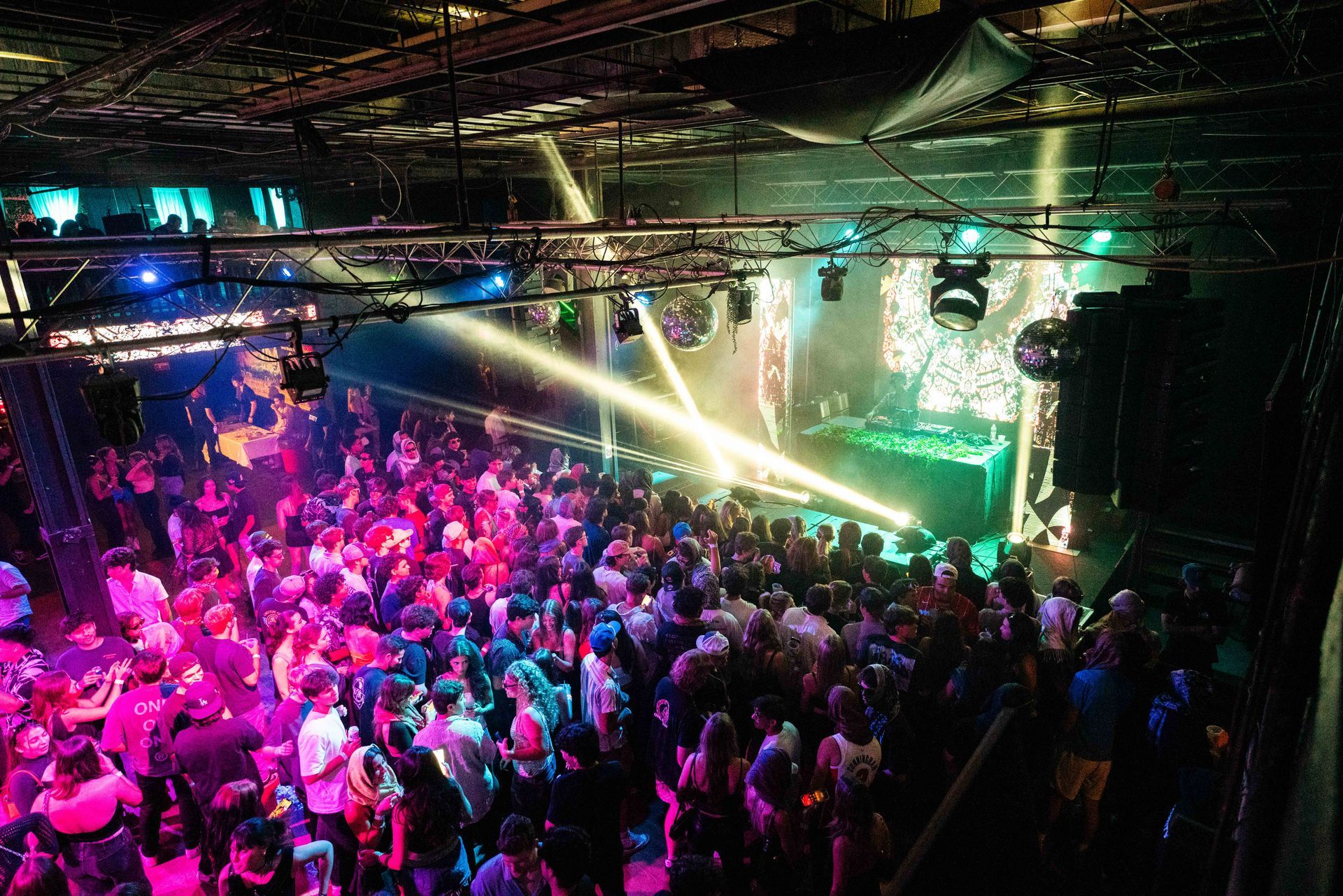 A large crowd of people are dancing in a club.