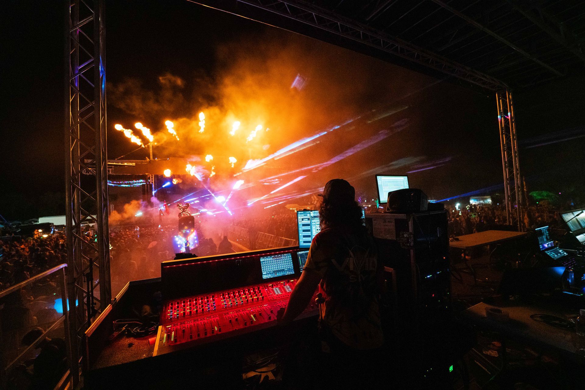 A dj is playing music at a concert with fireworks in the background