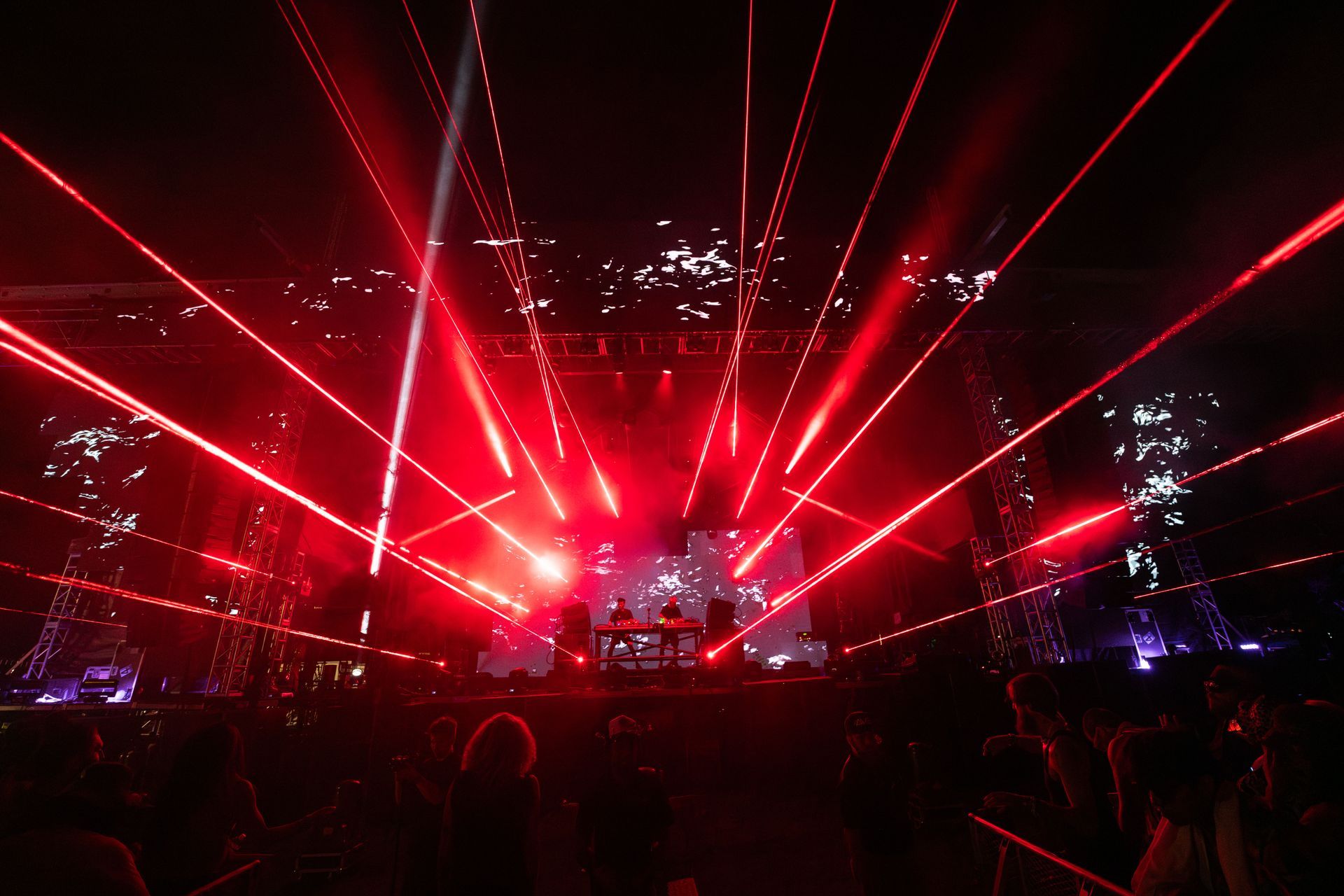 A group of people are standing in front of a stage with red lights coming out of it.