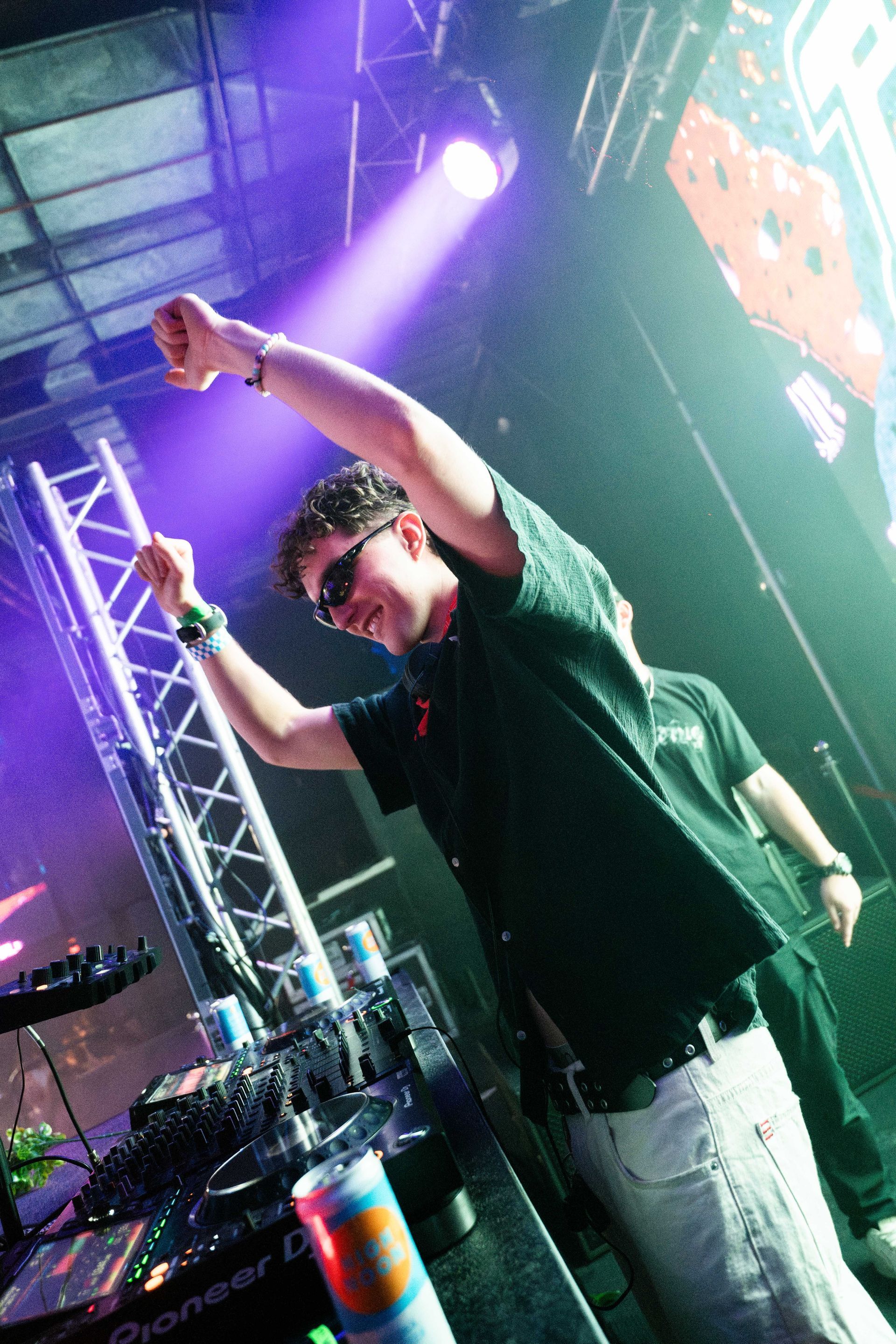 A man is standing on a stage with his arms in the air