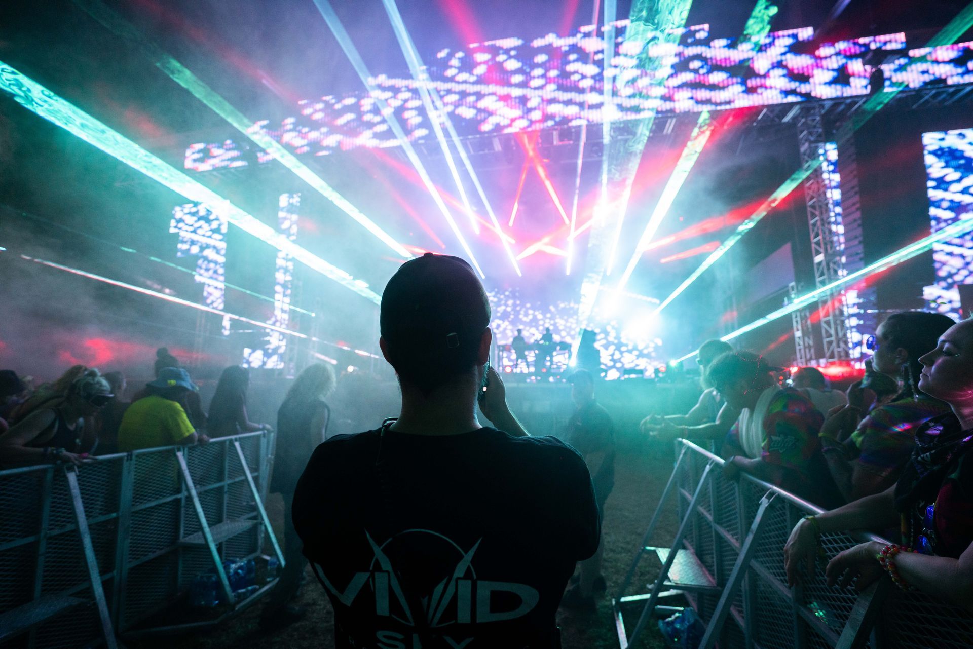 A man in a vivid shirt is watching a concert