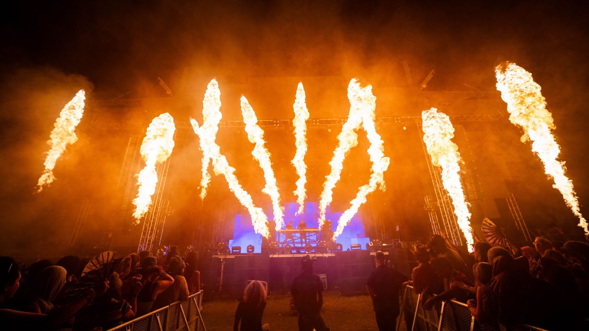 A crowd of people watching fireworks at a concert.
