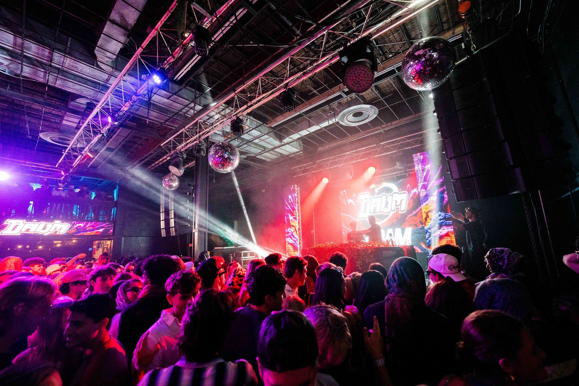 A crowd of people are standing in front of a stage at a concert.