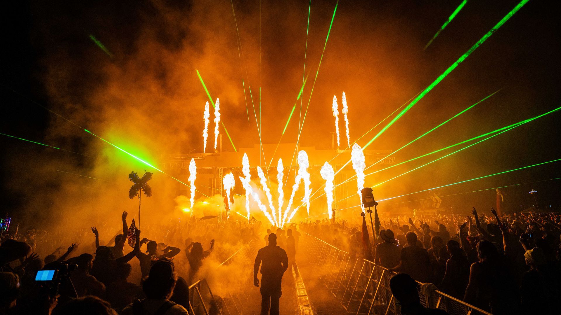 A man is standing in front of a crowd of people at a concert.