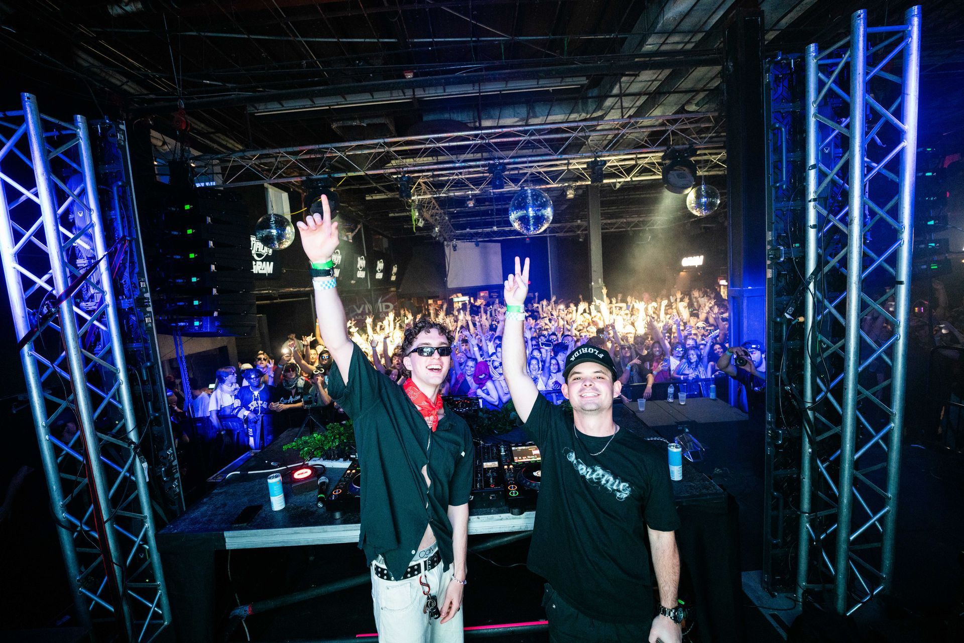Two men are standing in front of a crowd at a concert.