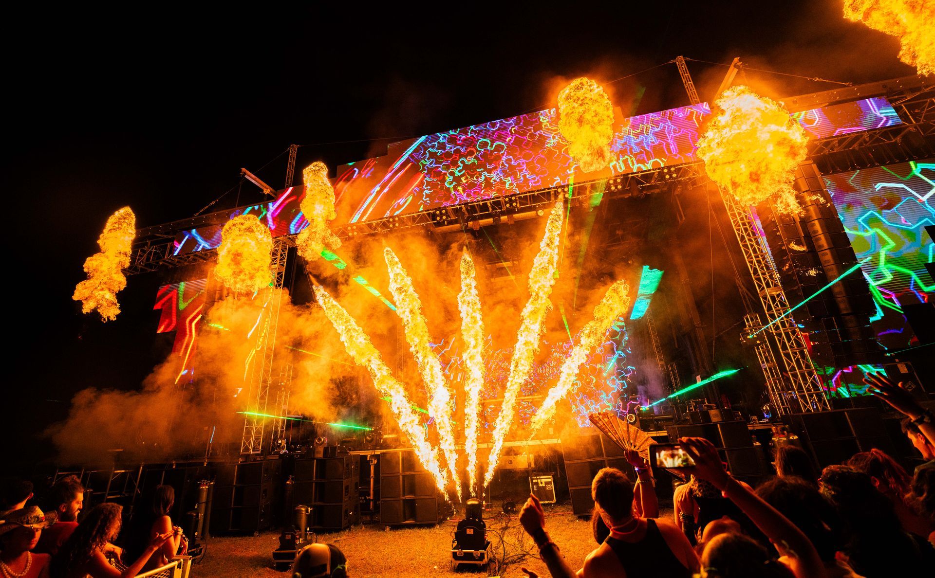 A crowd of people are watching fireworks at a concert.