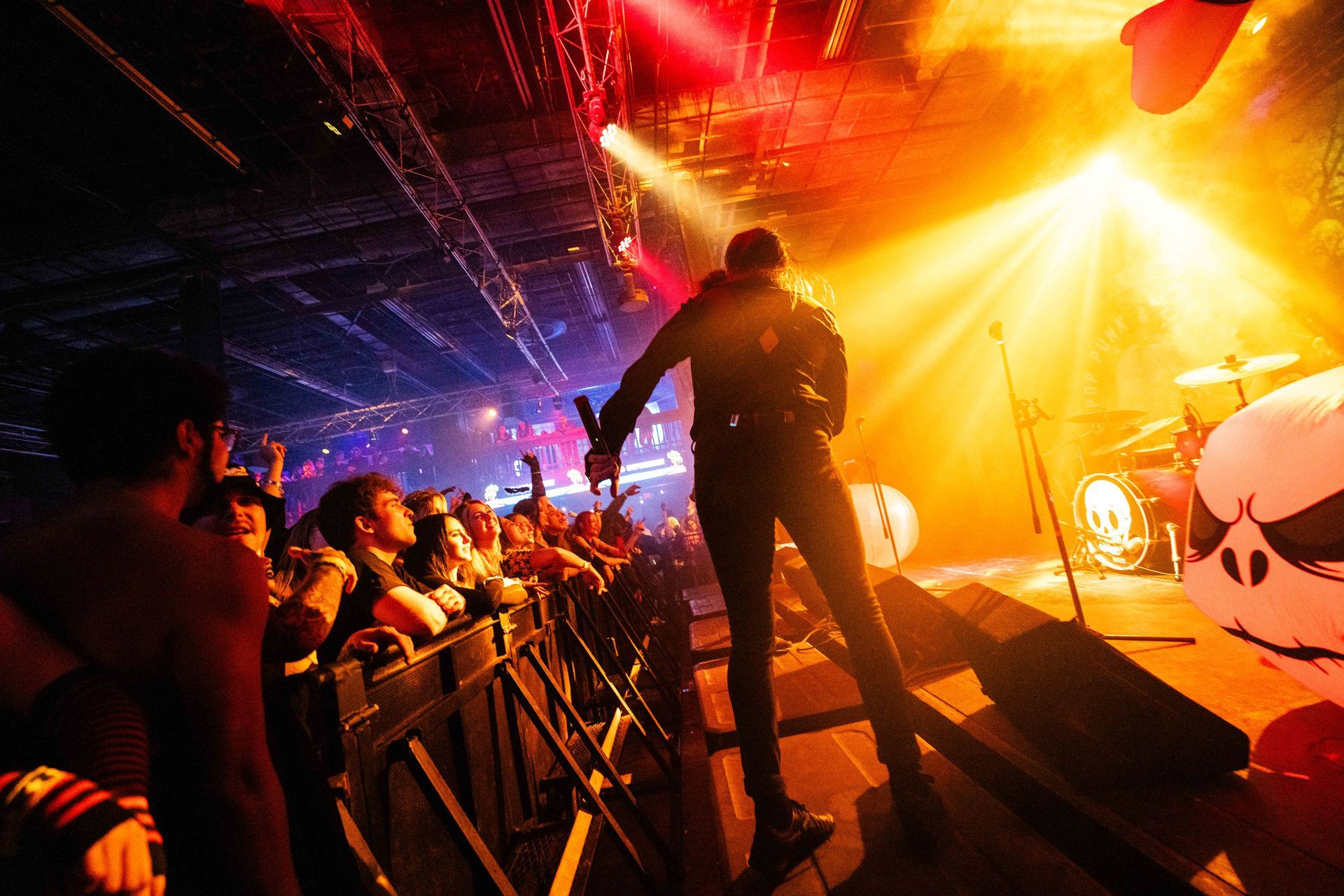 A man is singing into a microphone on a stage in front of a crowd.