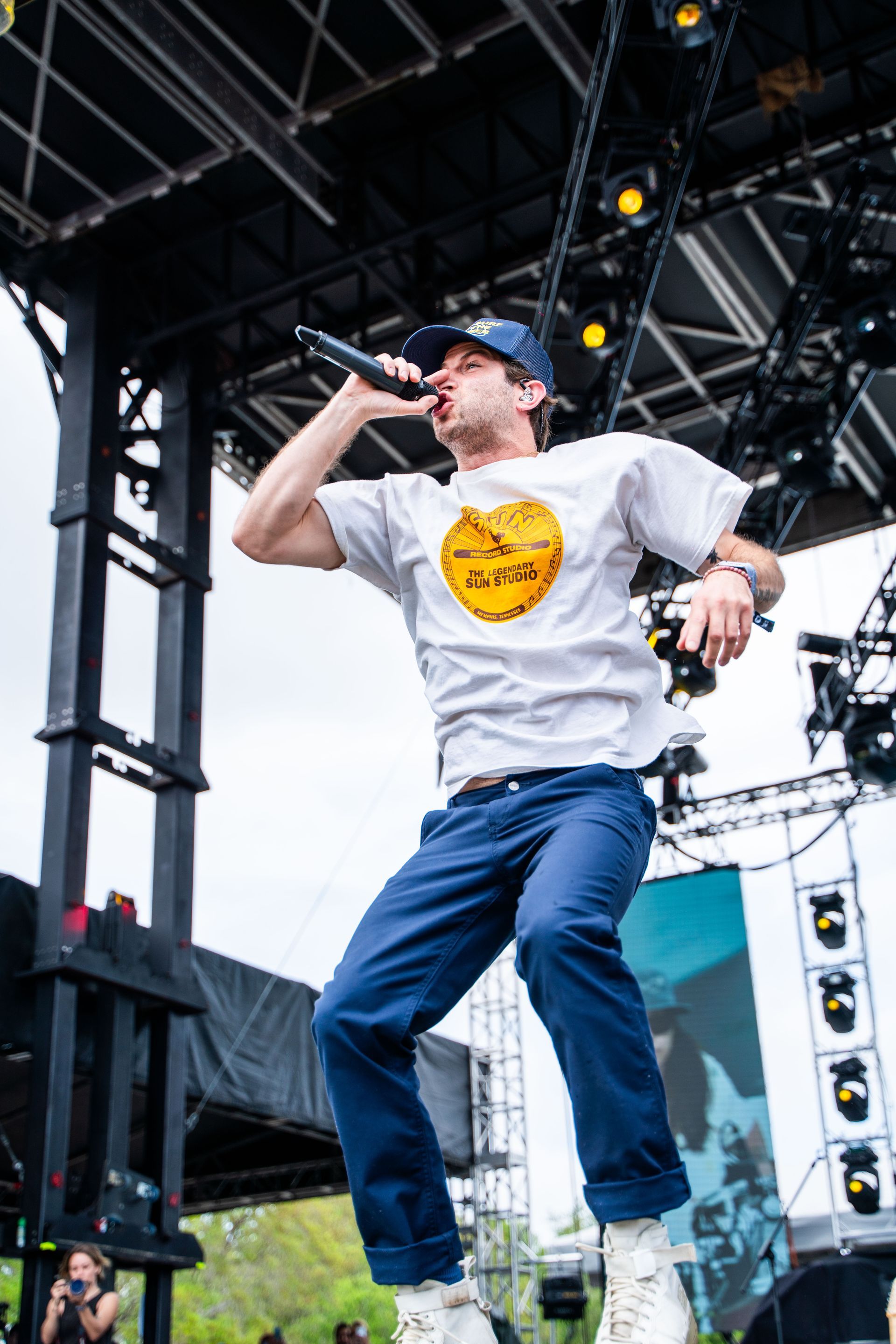 A man is singing into a microphone on a stage.