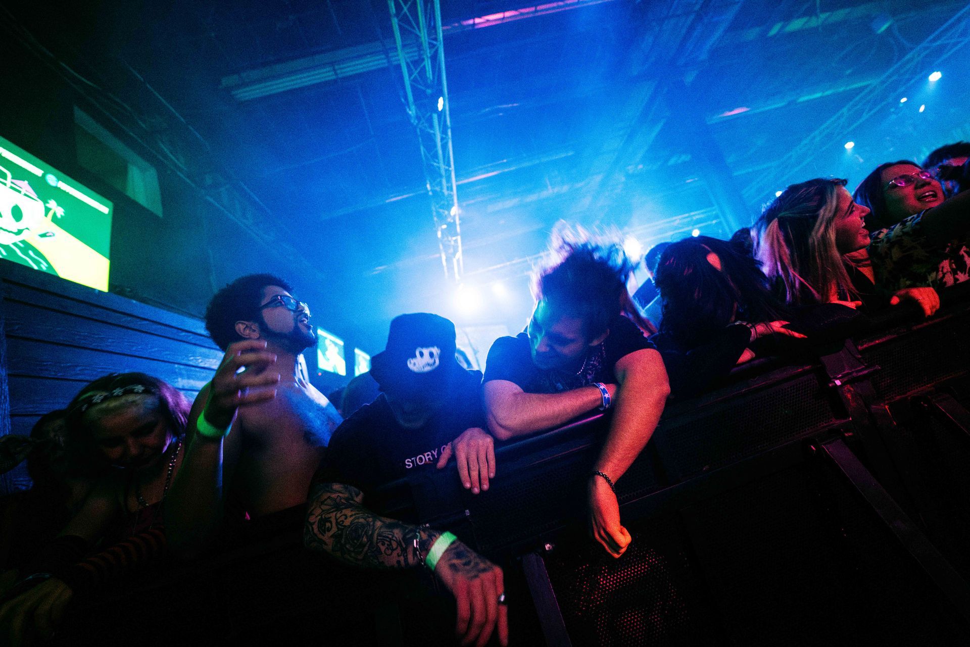 A group of people are sitting in a dark room watching a concert.