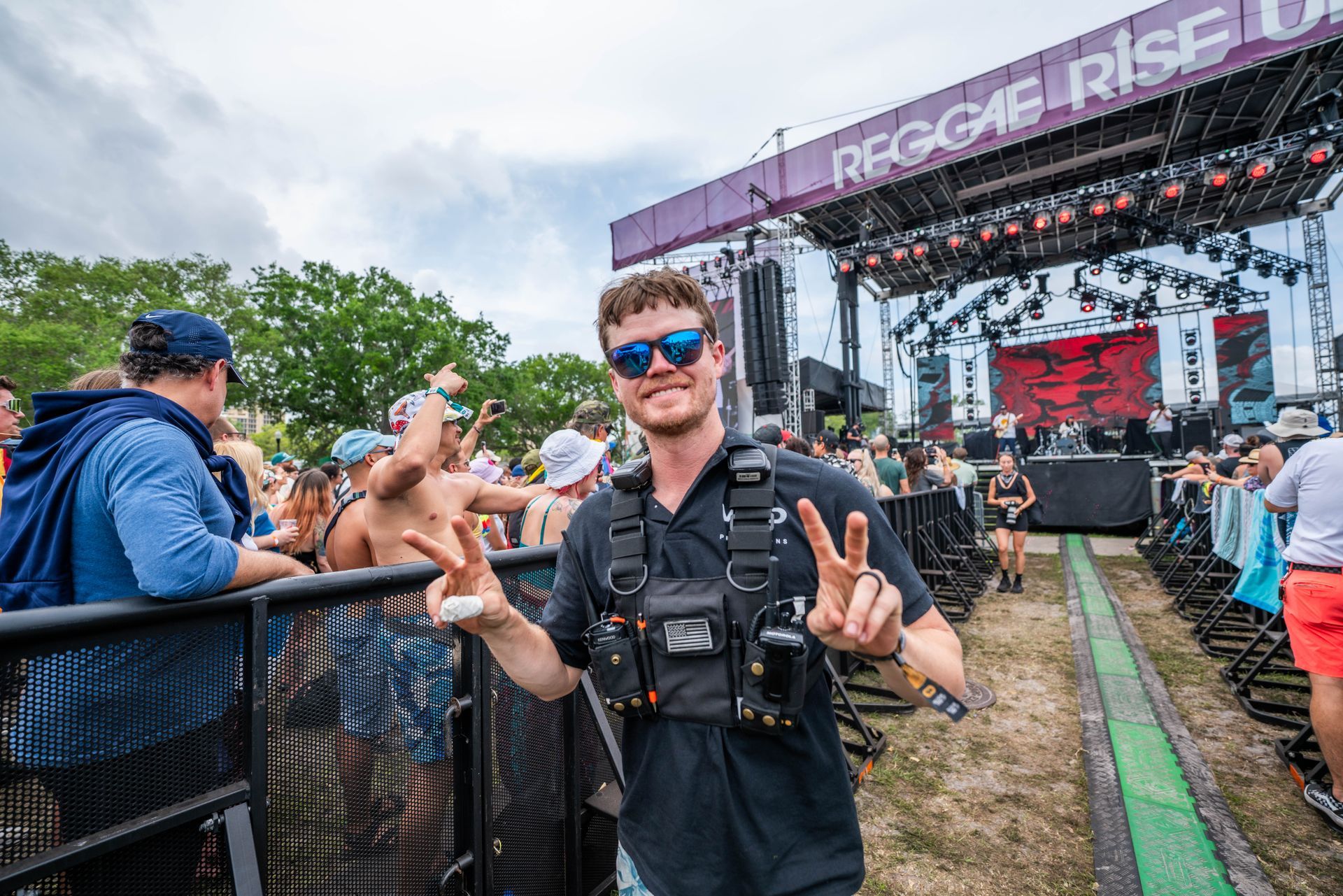 A man is standing in front of a crowd at a music festival.