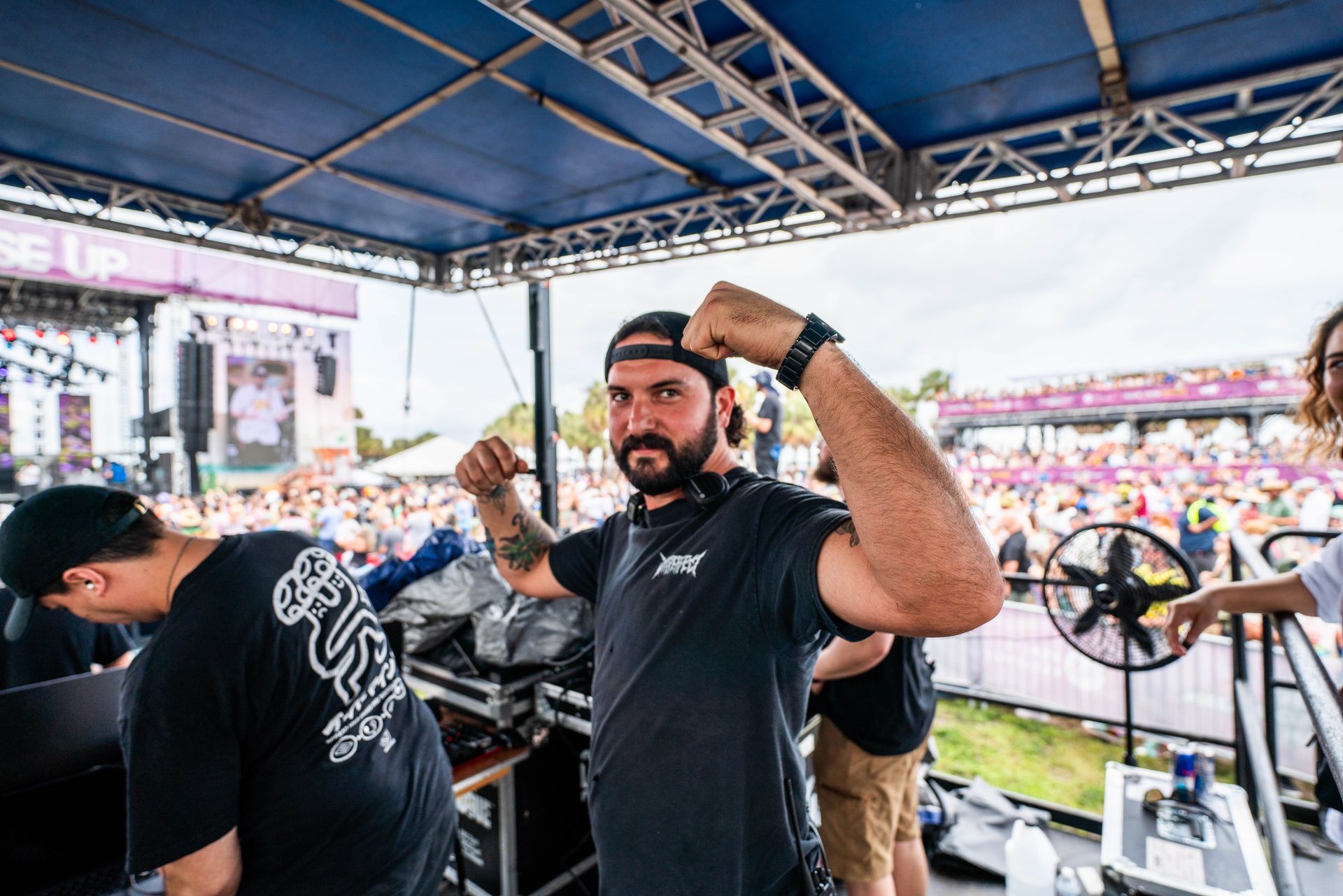 A man with a beard is flexing his muscles on a stage.