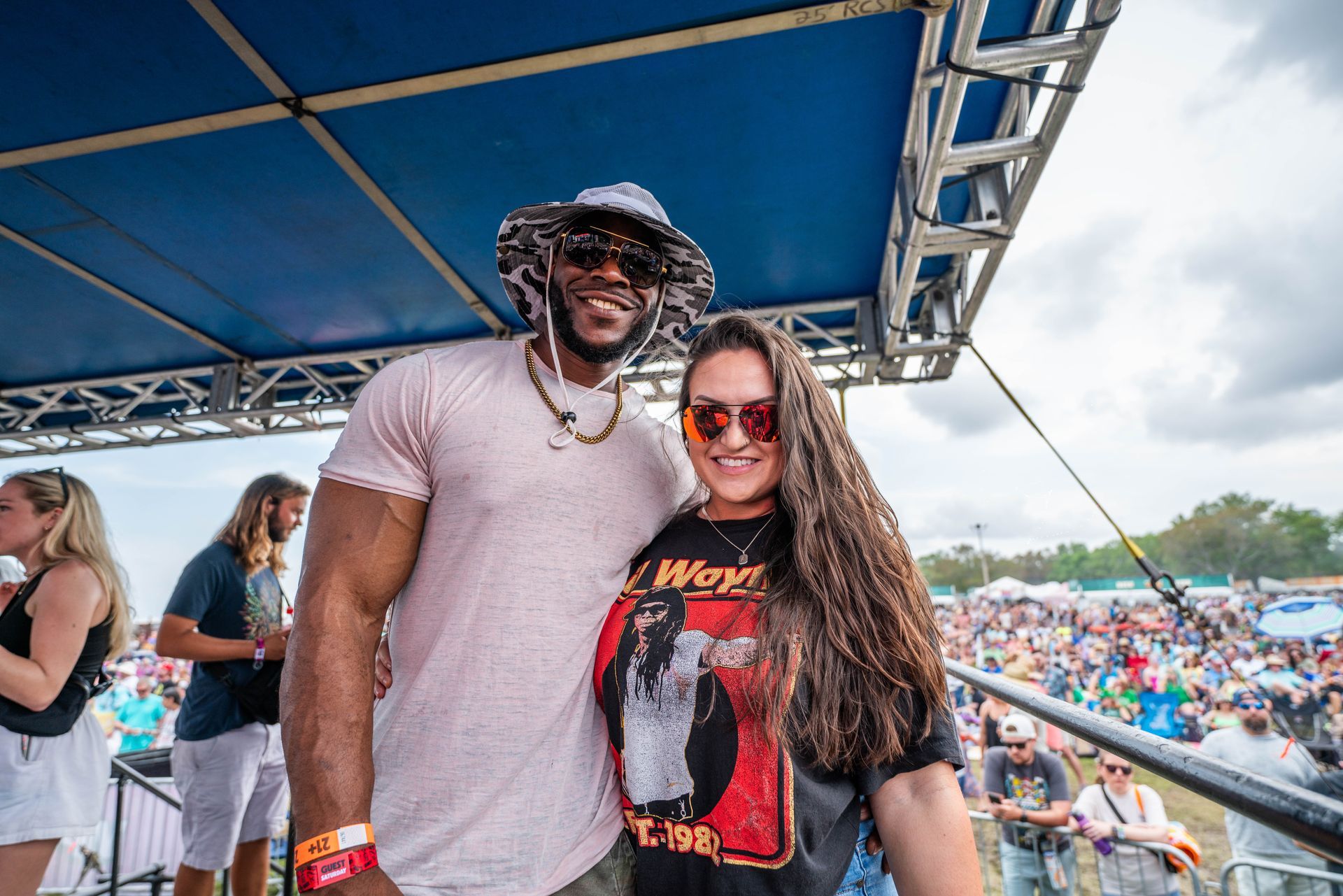 A man and a woman are posing for a picture at a concert.