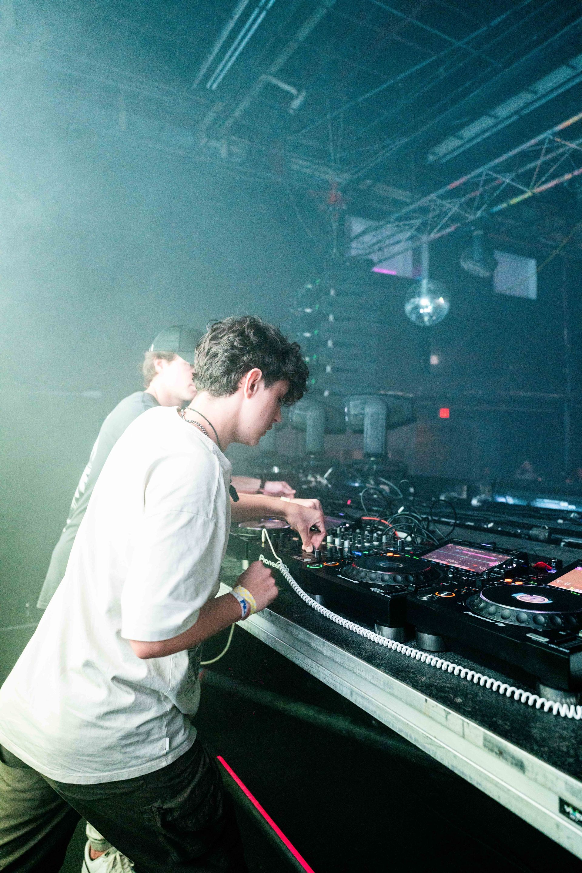 Two men are playing music in a dark room.