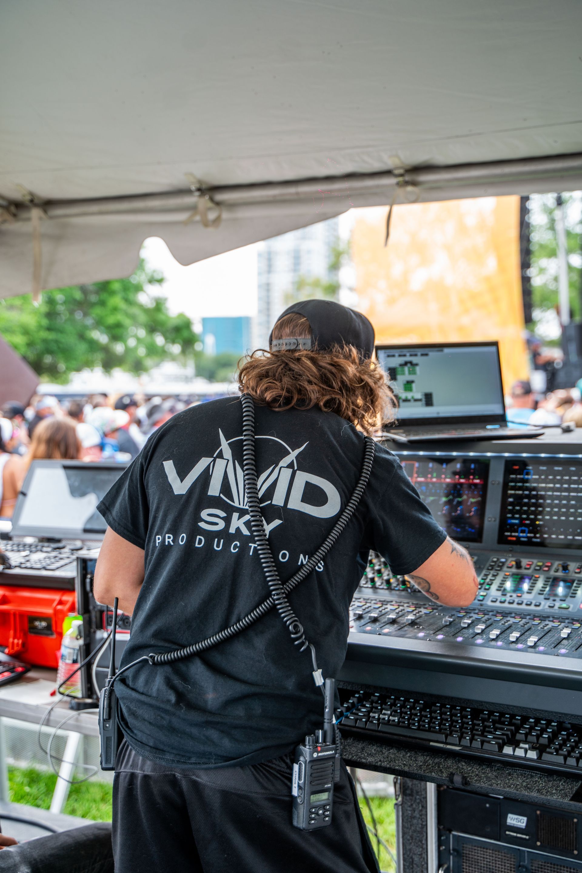 A man is standing in front of a mixer in a tent.