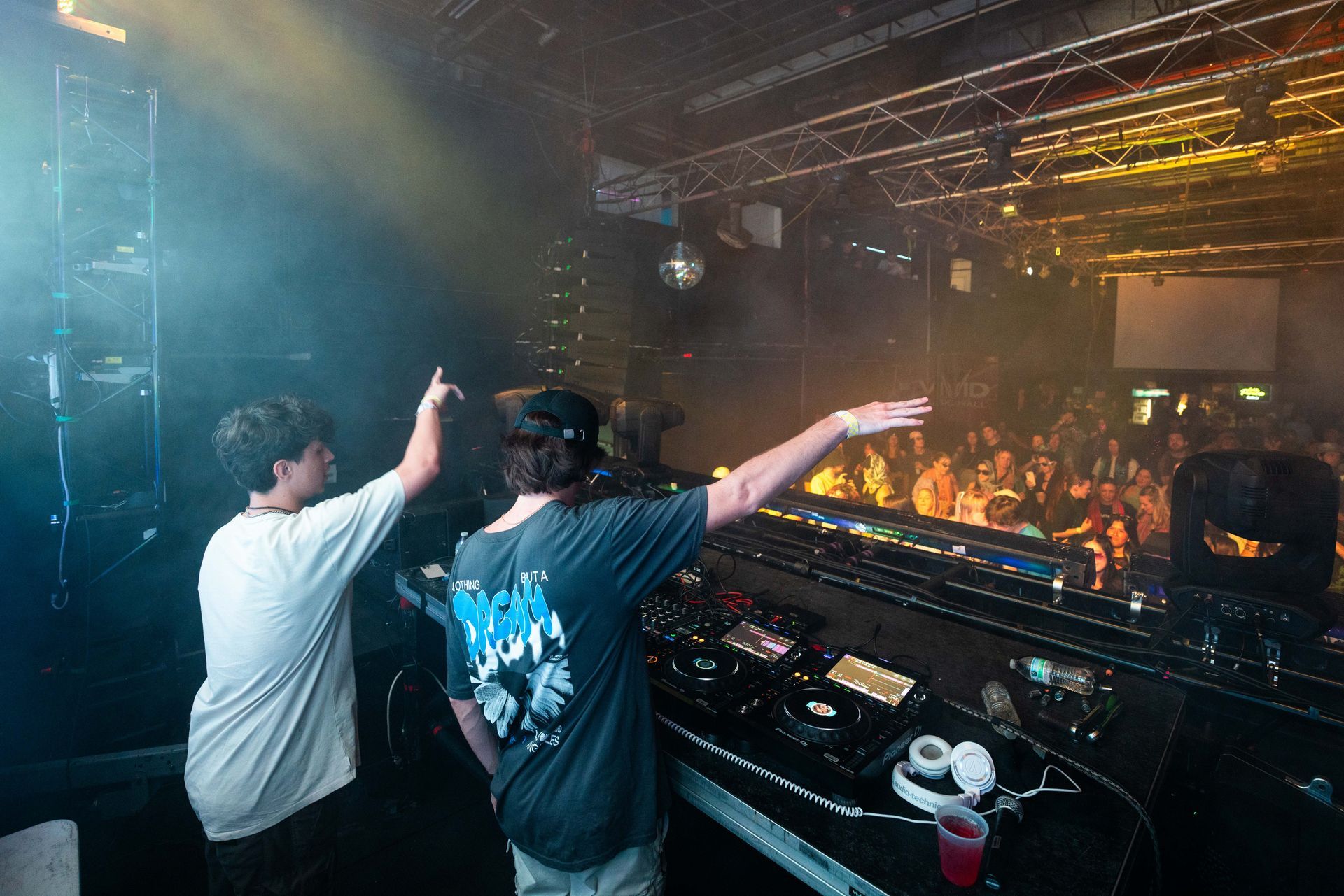 Two men are playing music on a stage in front of a crowd.