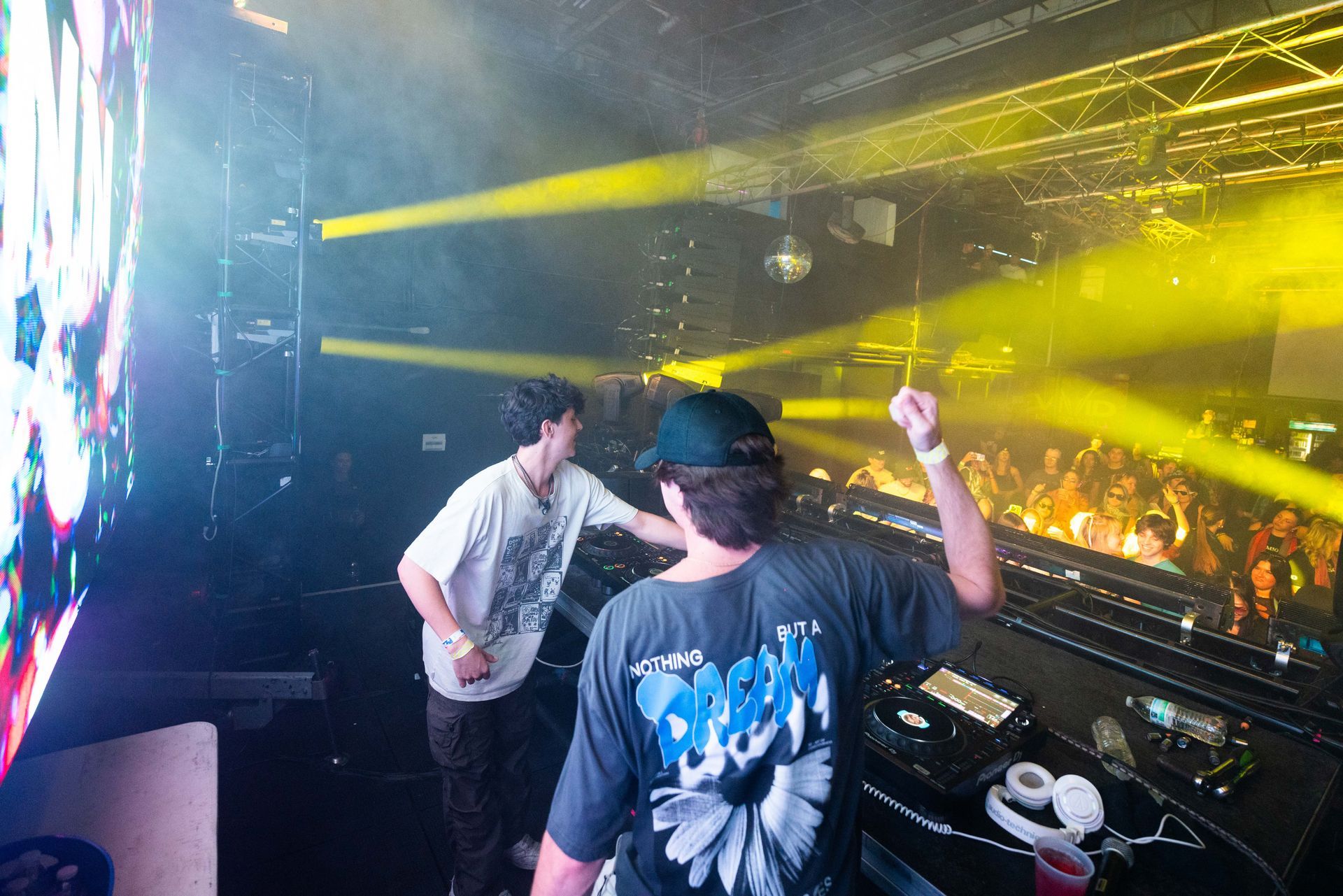 Two men are standing in front of a crowd at a concert.