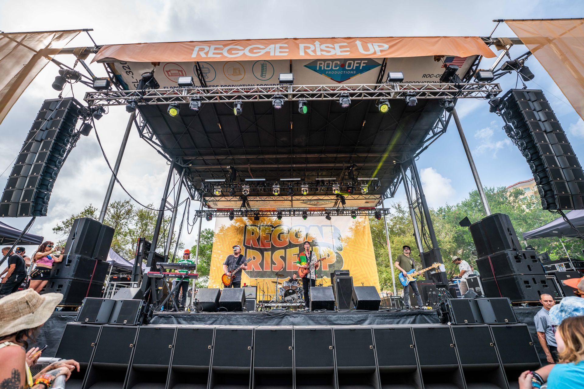 A large stage with a sign that says reggae rise up on it.