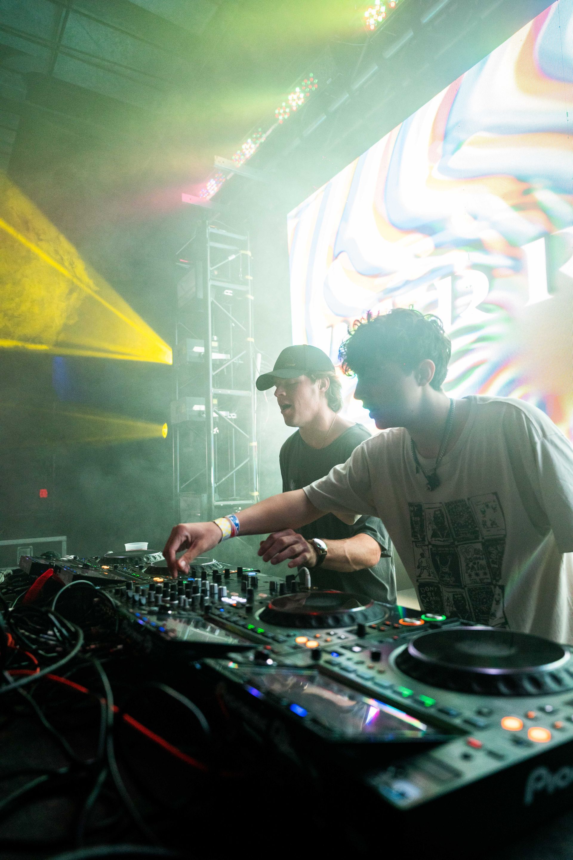 Two men are playing music on a stage at a concert.