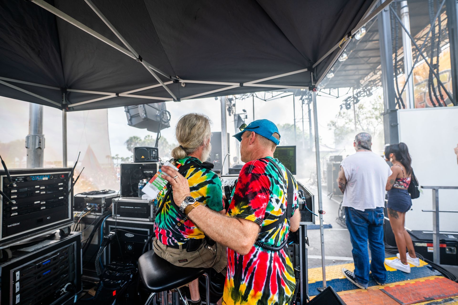 A man and a woman are sitting under a tent.