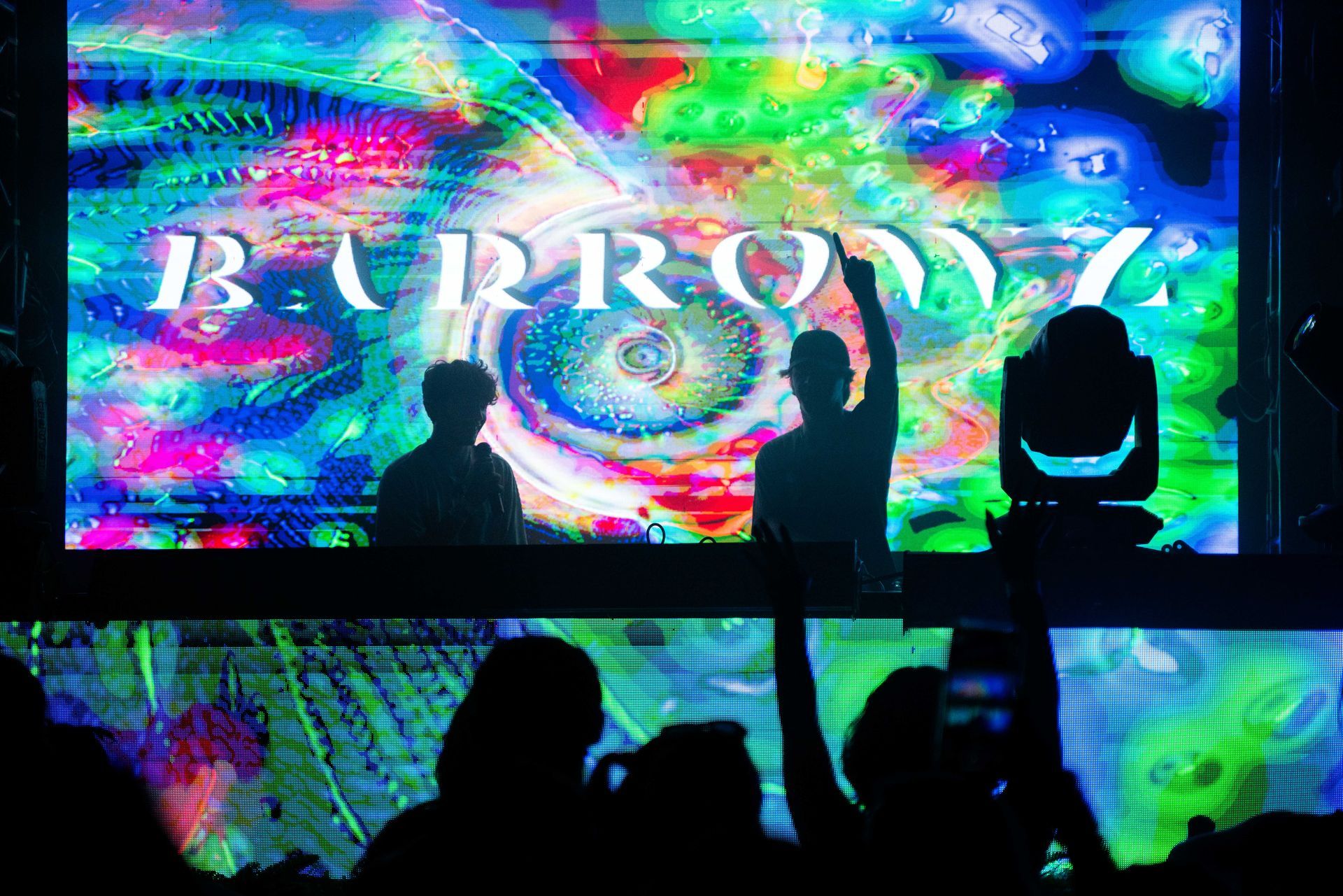 A group of people are standing in front of a large screen.