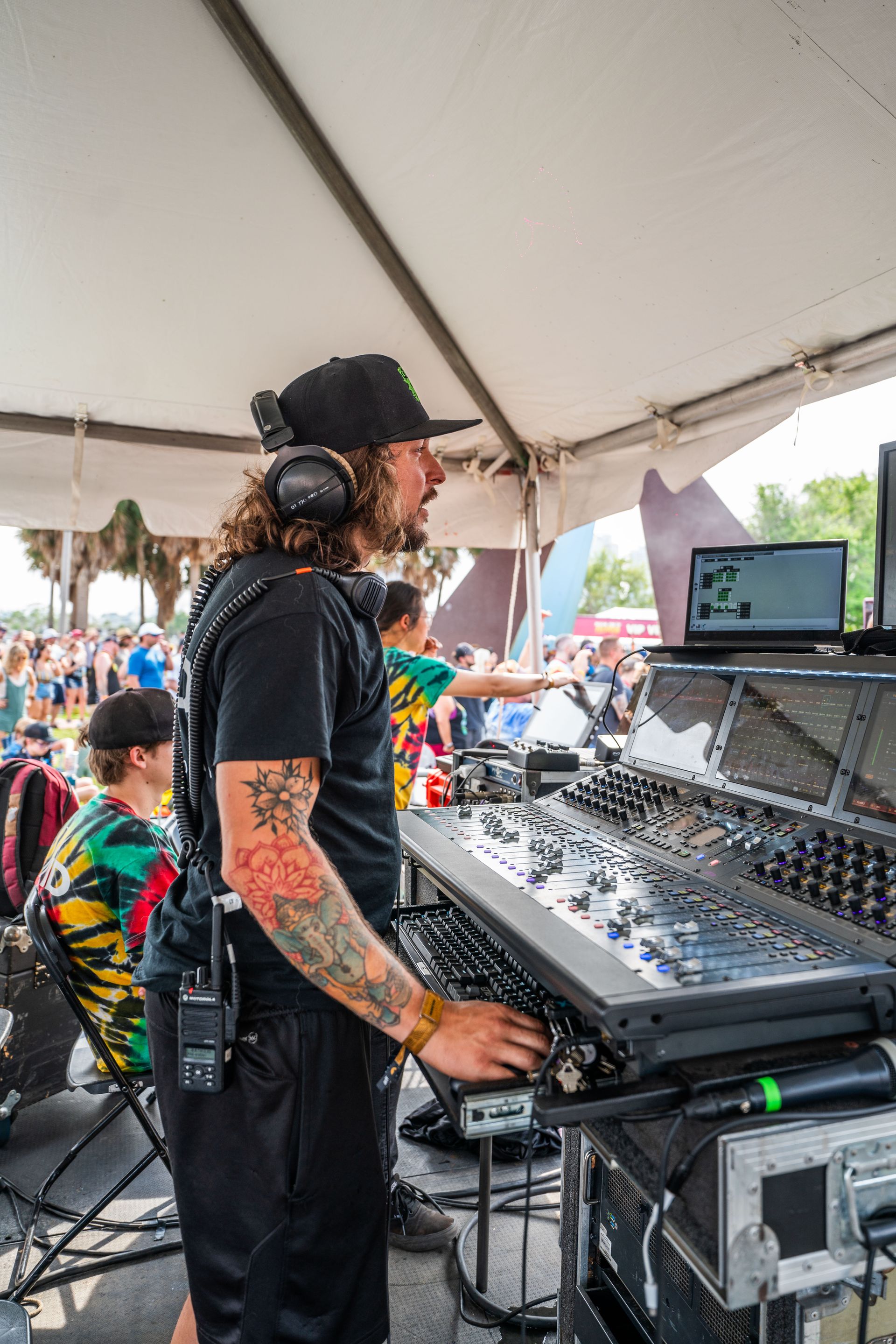 A man is standing in front of a mixer in a tent.
