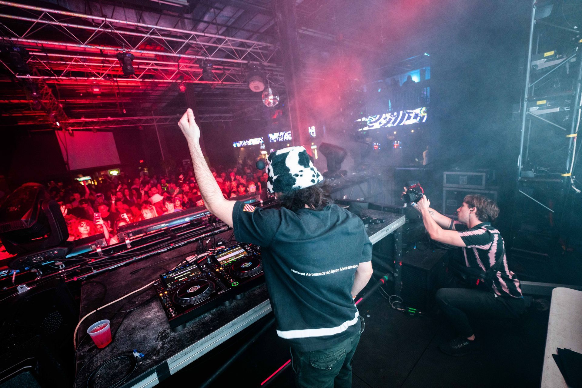 Two men are playing music on a stage in front of a crowd.