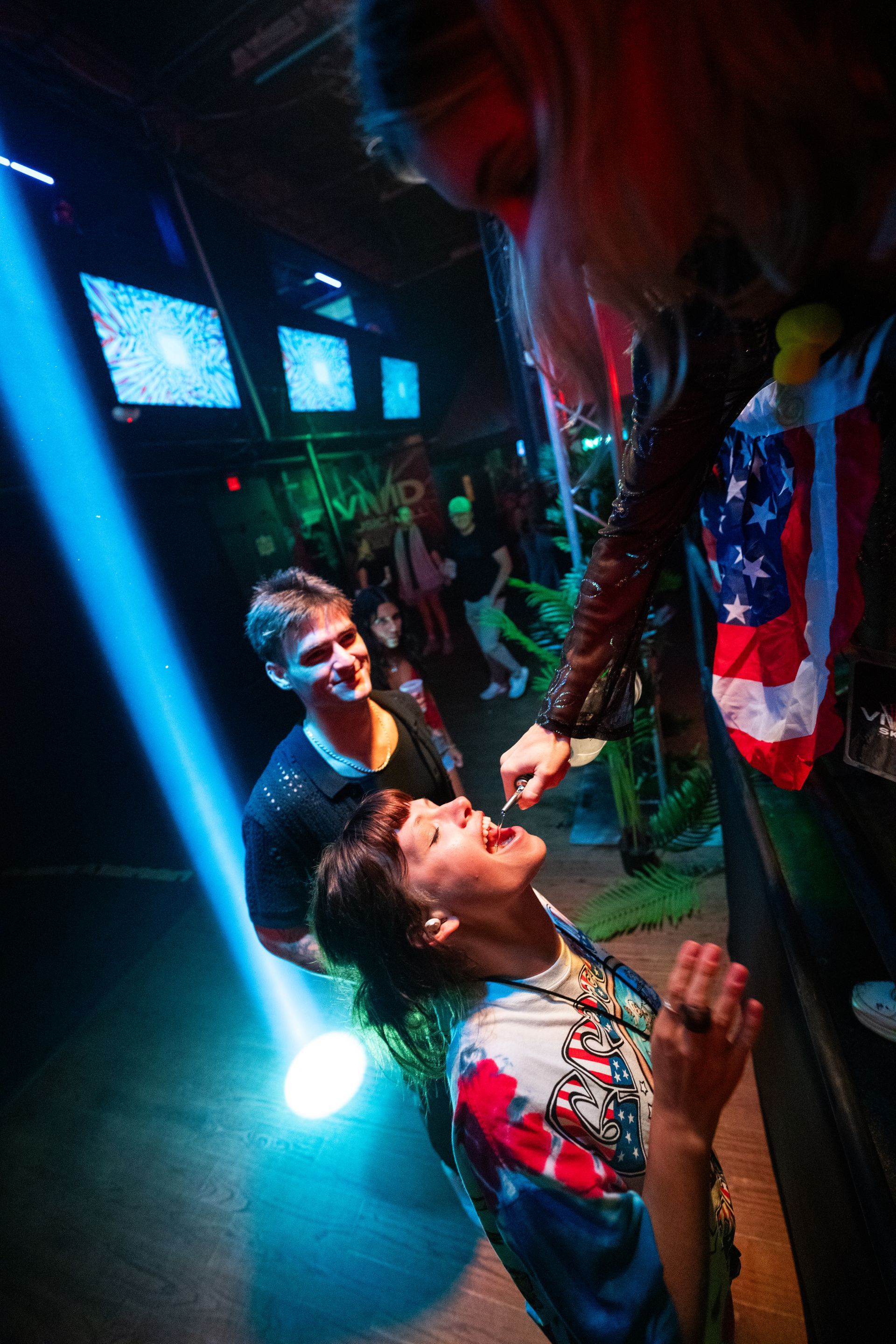 A group of people are standing in a dark room.
