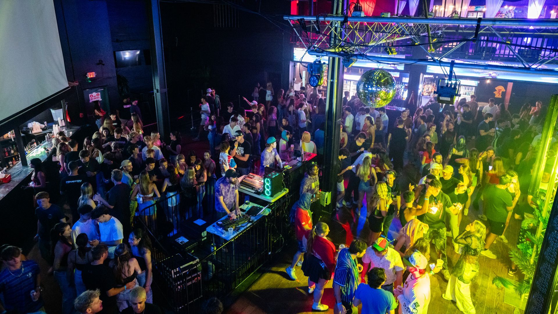 A large crowd of people are dancing in a club.