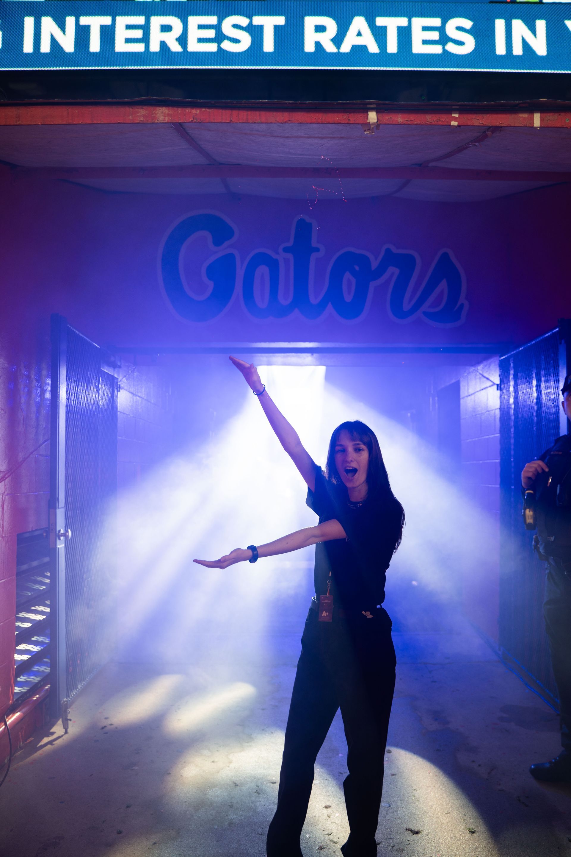 A woman stands in front of a sign that says interest rates in gators