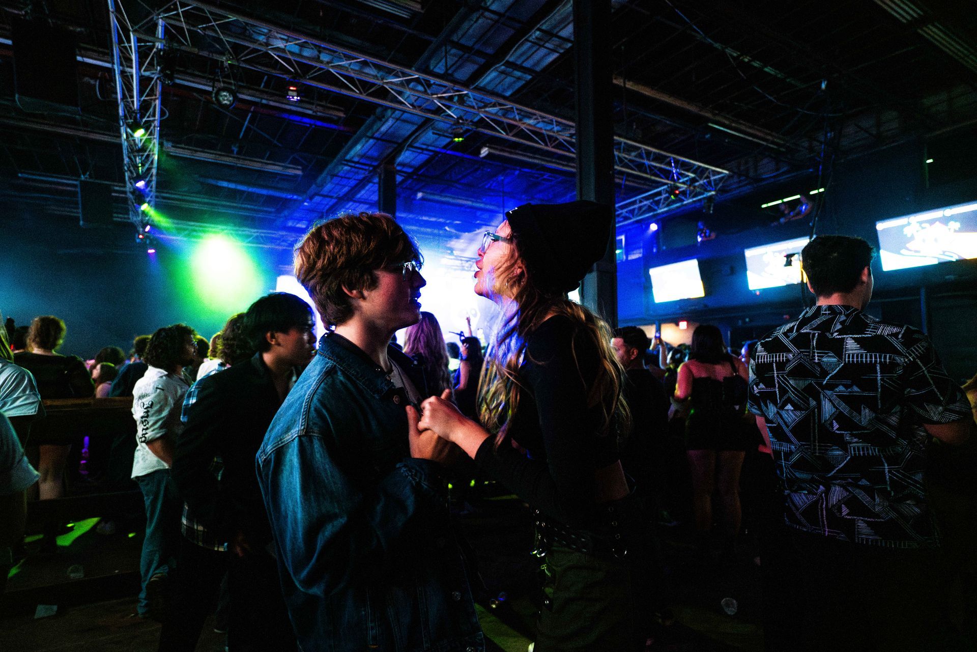 A group of people are dancing in a dark room.