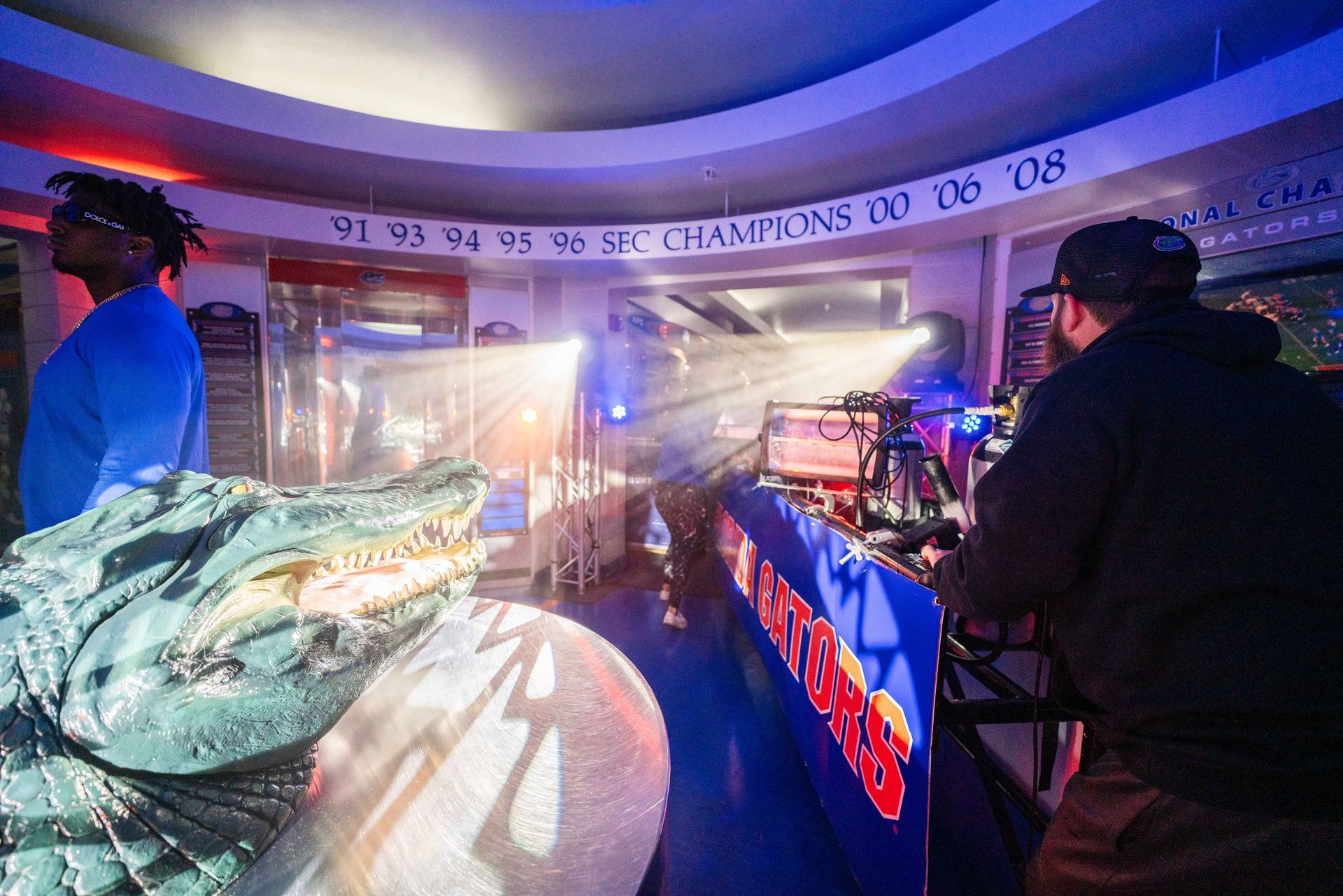 A man is standing next to a statue of a dragon in a room.
