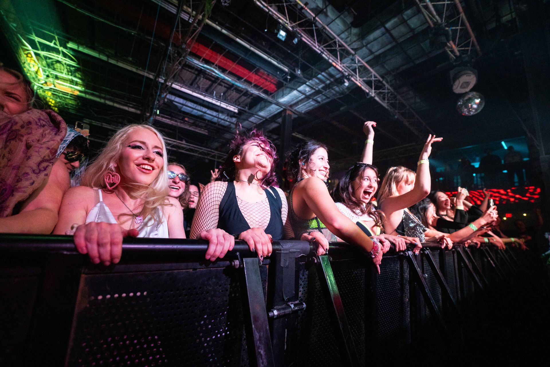 A group of women are standing in a crowd at a concert.