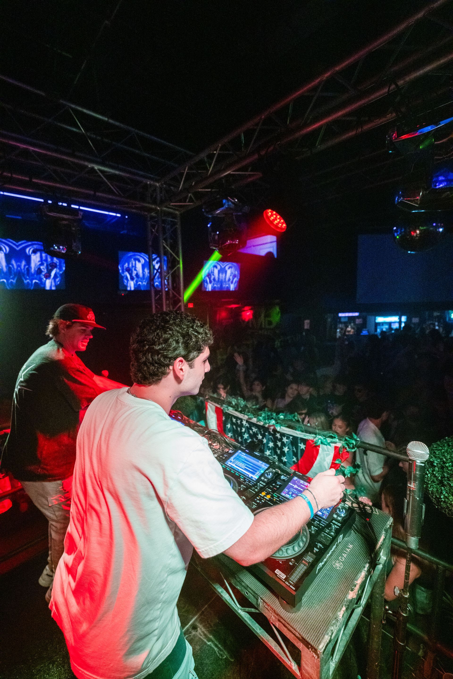 A man is playing a dj set in front of a crowd.