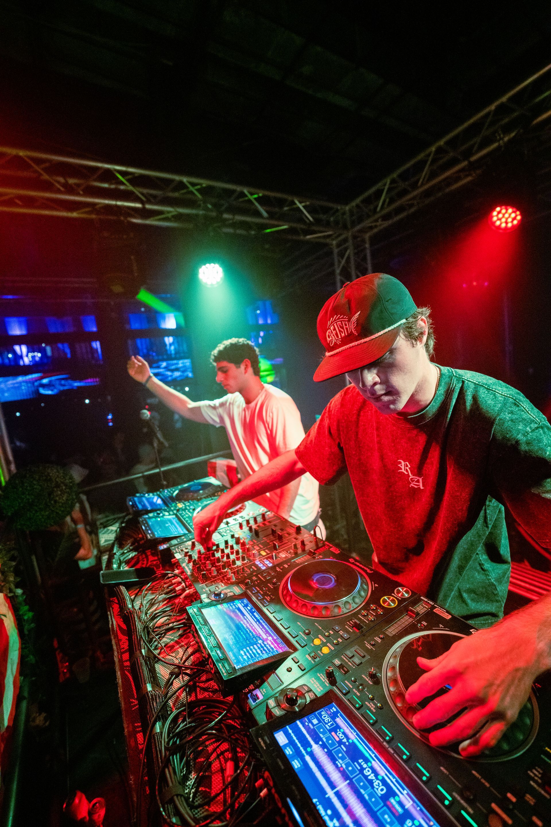 Two young men are playing music in a club.