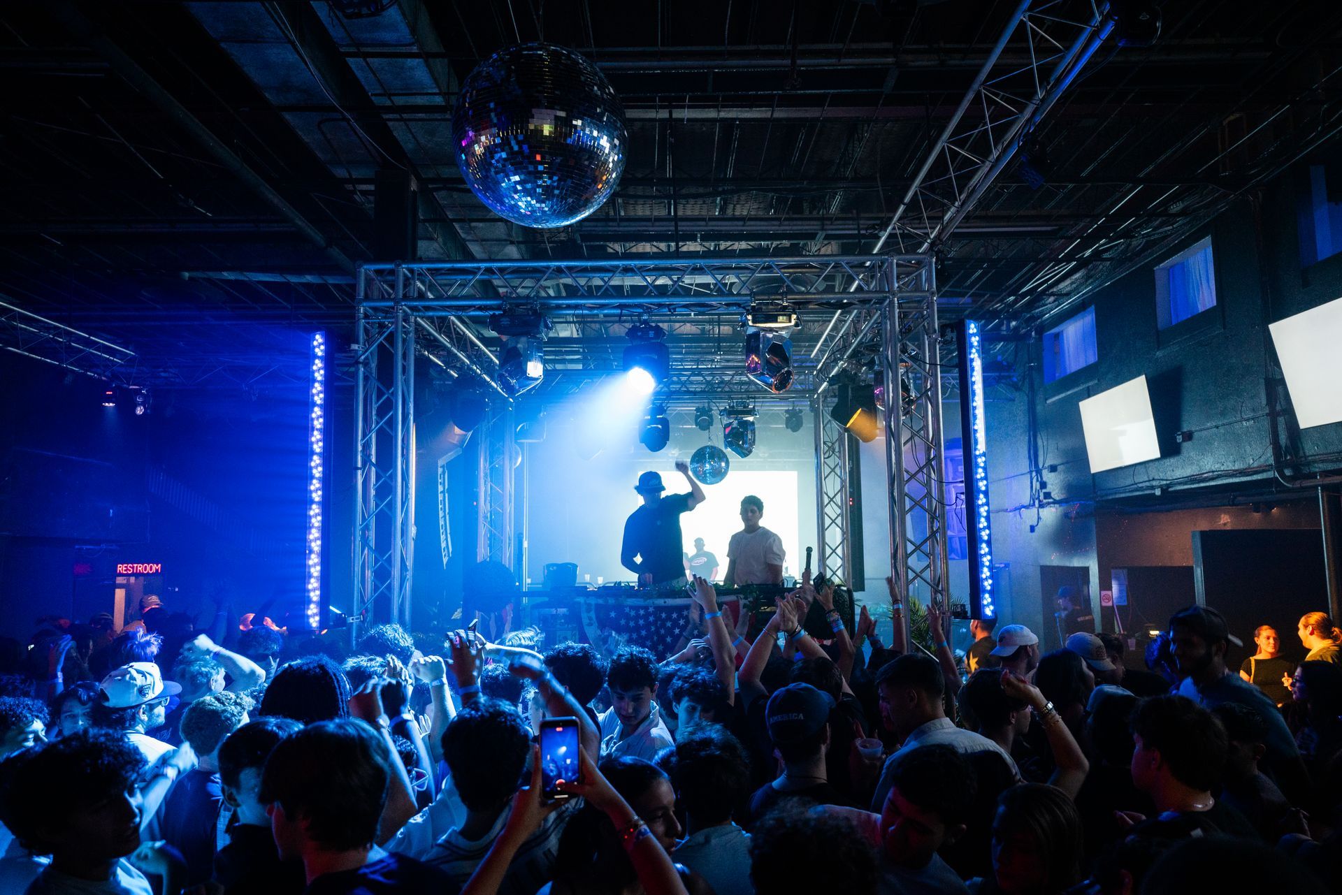 A crowd of people are standing in front of a stage at a concert.