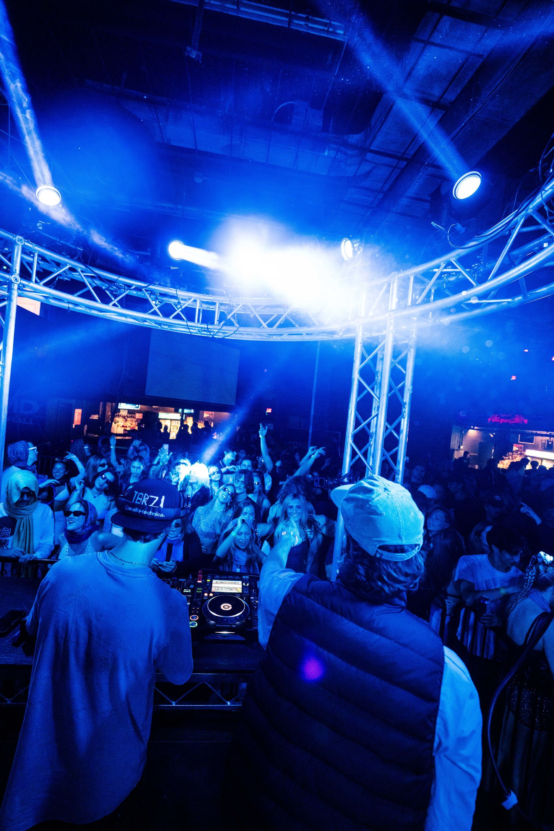 A dj is playing music in front of a crowd at a party.