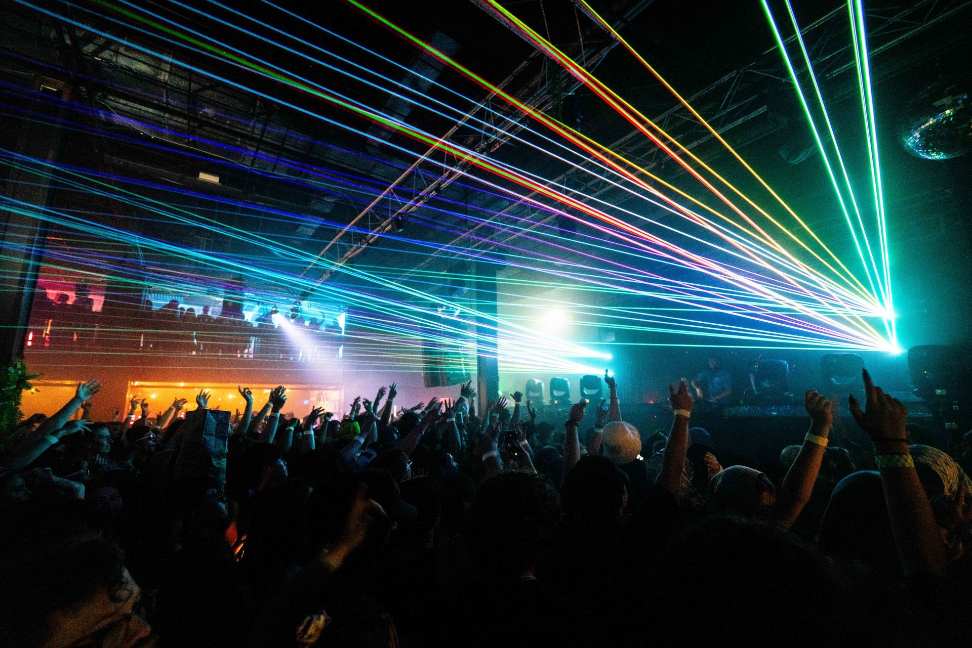 A crowd of people at a concert with their hands in the air.