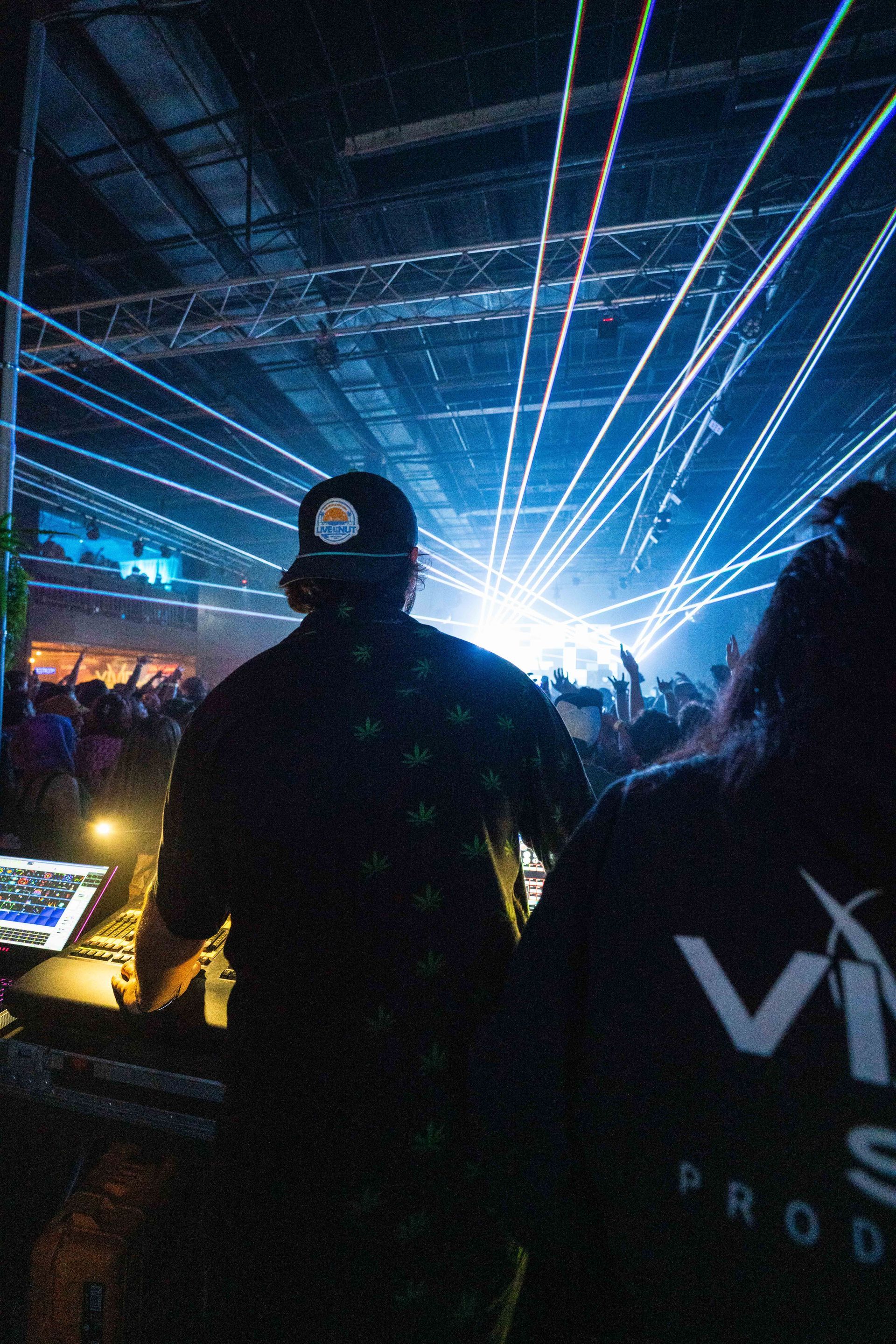 A man and a woman are standing in front of a crowd at a concert.