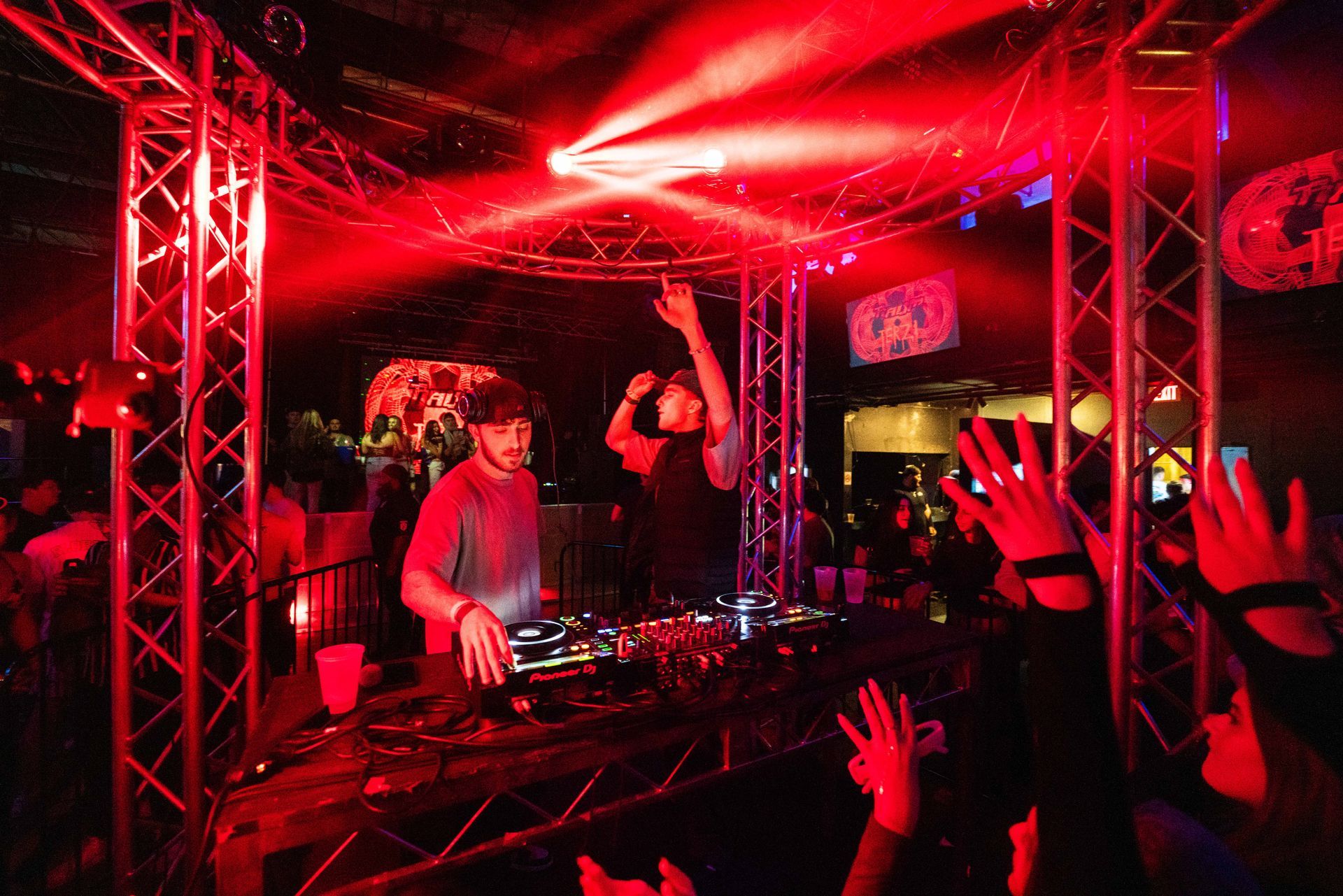 Two men are playing music on a stage in front of a crowd.