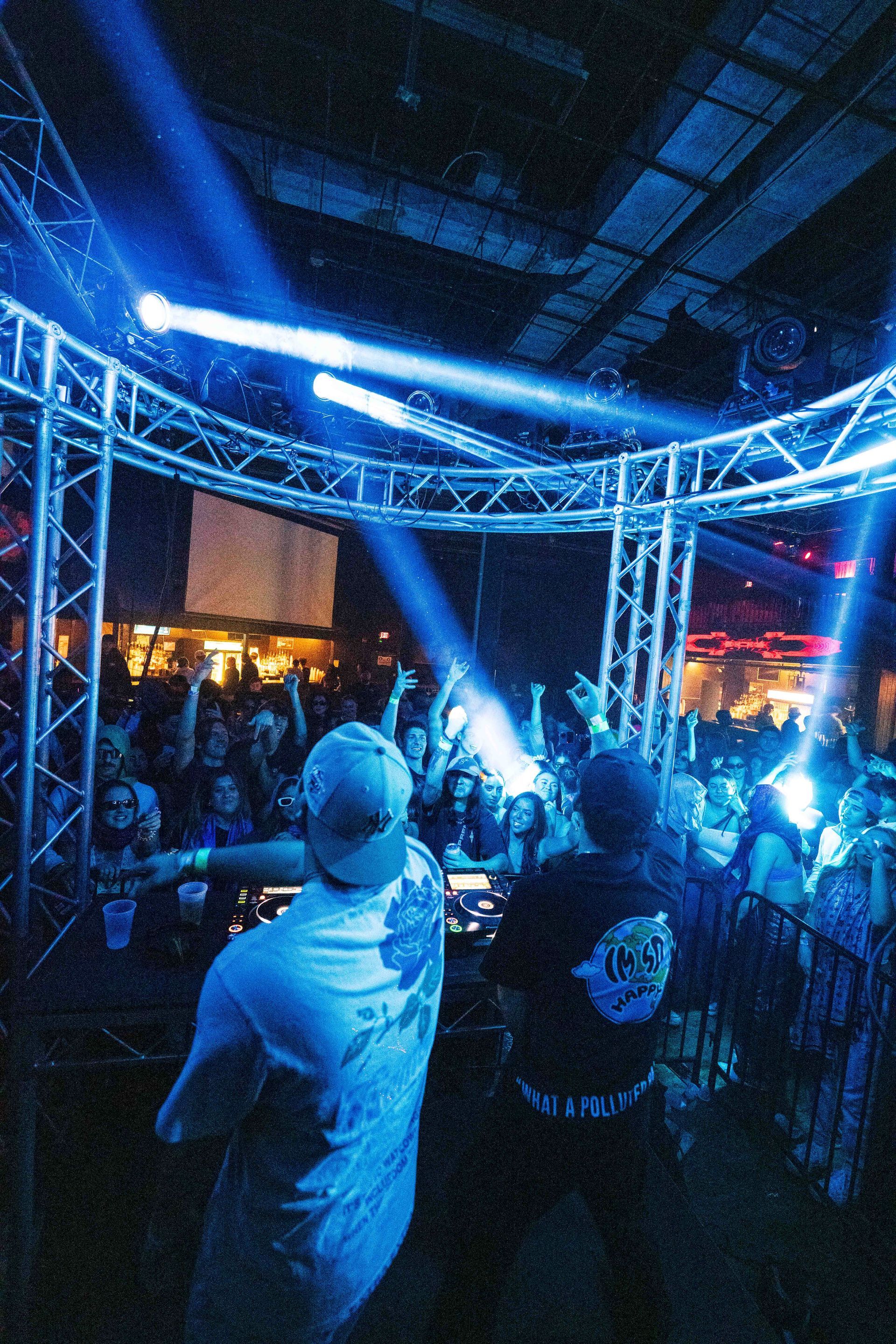 A man is standing in front of a crowd at a concert.