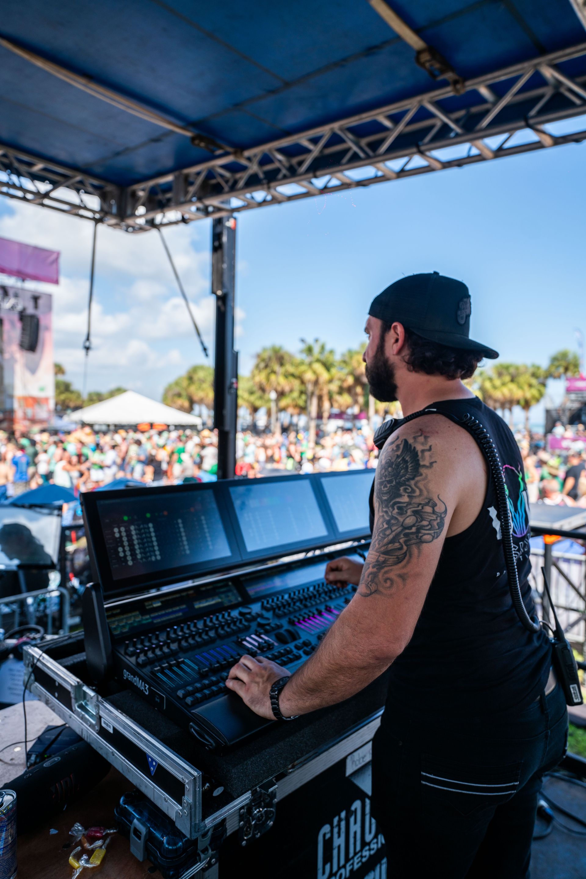 A man is standing in front of a mixer at a concert.