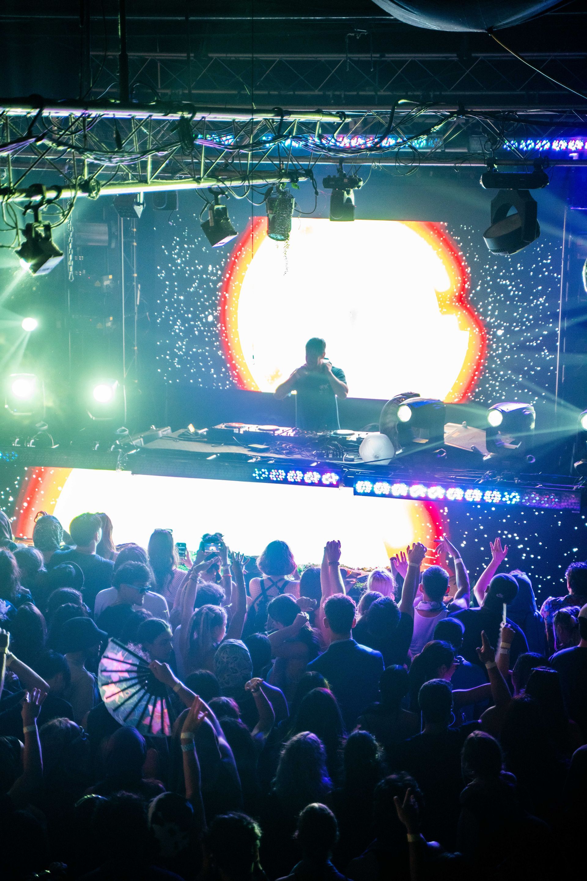 A dj is playing music in front of a crowd of people at a party.