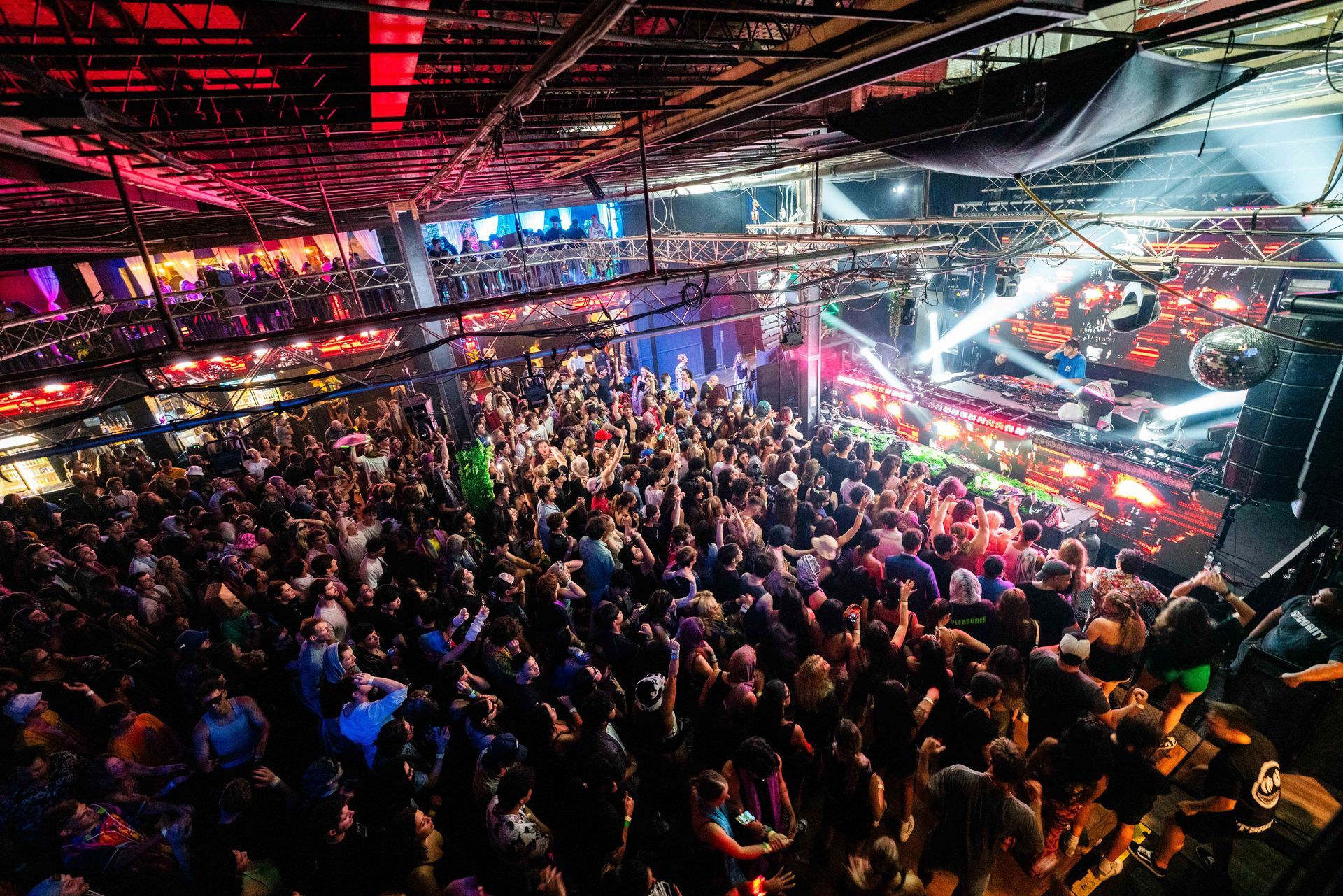 A large crowd of people are gathered in a large room at a concert.