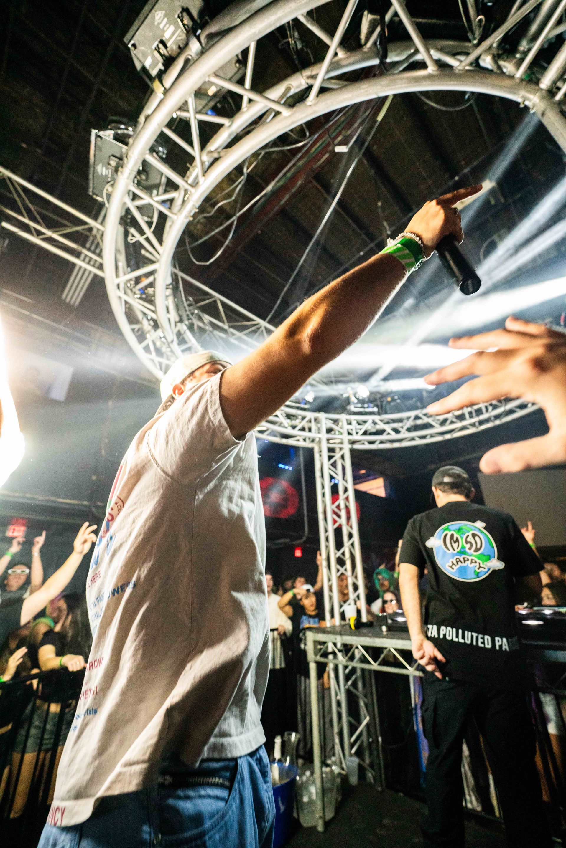 A man is holding a microphone in front of a crowd at a concert.